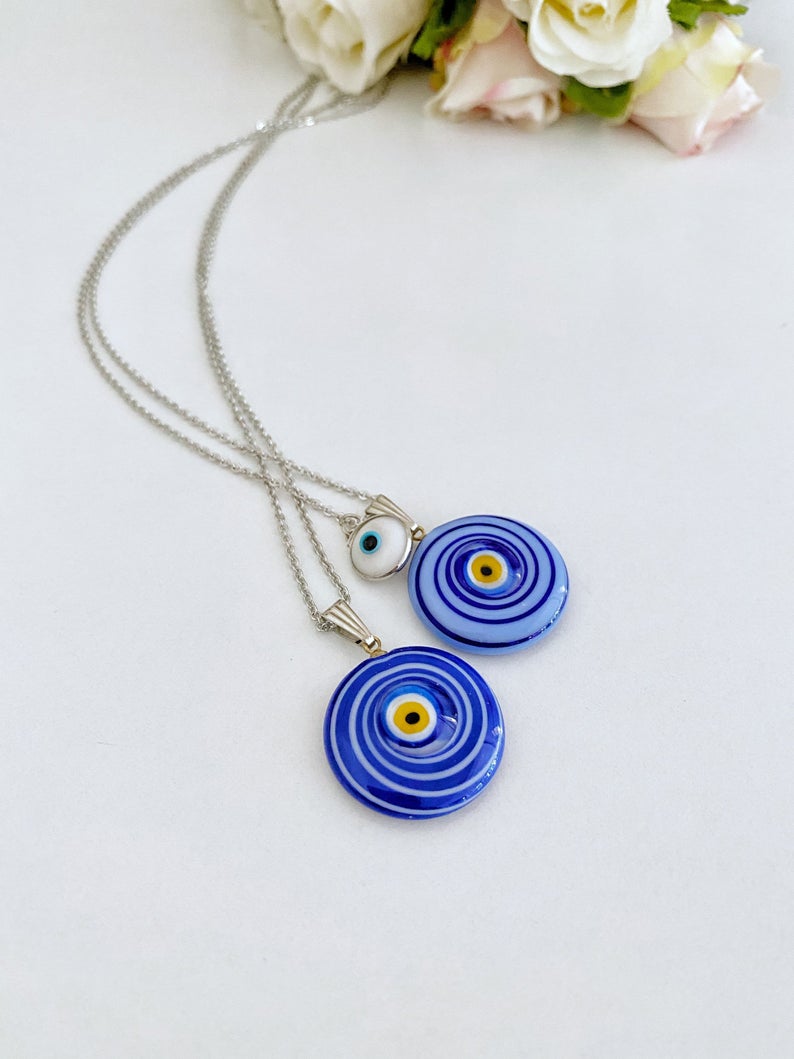 Elegant Evil Eye Necklace featuring a large Murano glass bead in blue or turquoise, complemented by a silver chain and optional white evil eye bead.
