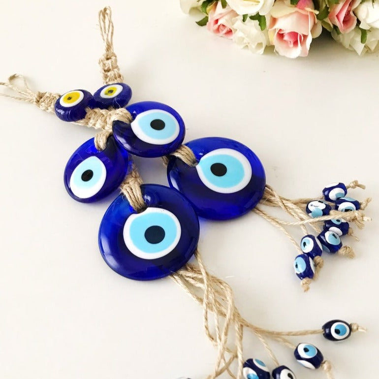 Handmade evil eye protection wall hanging featuring 11 unique blue evil eye beads and macrame design, perfect for home decoration.