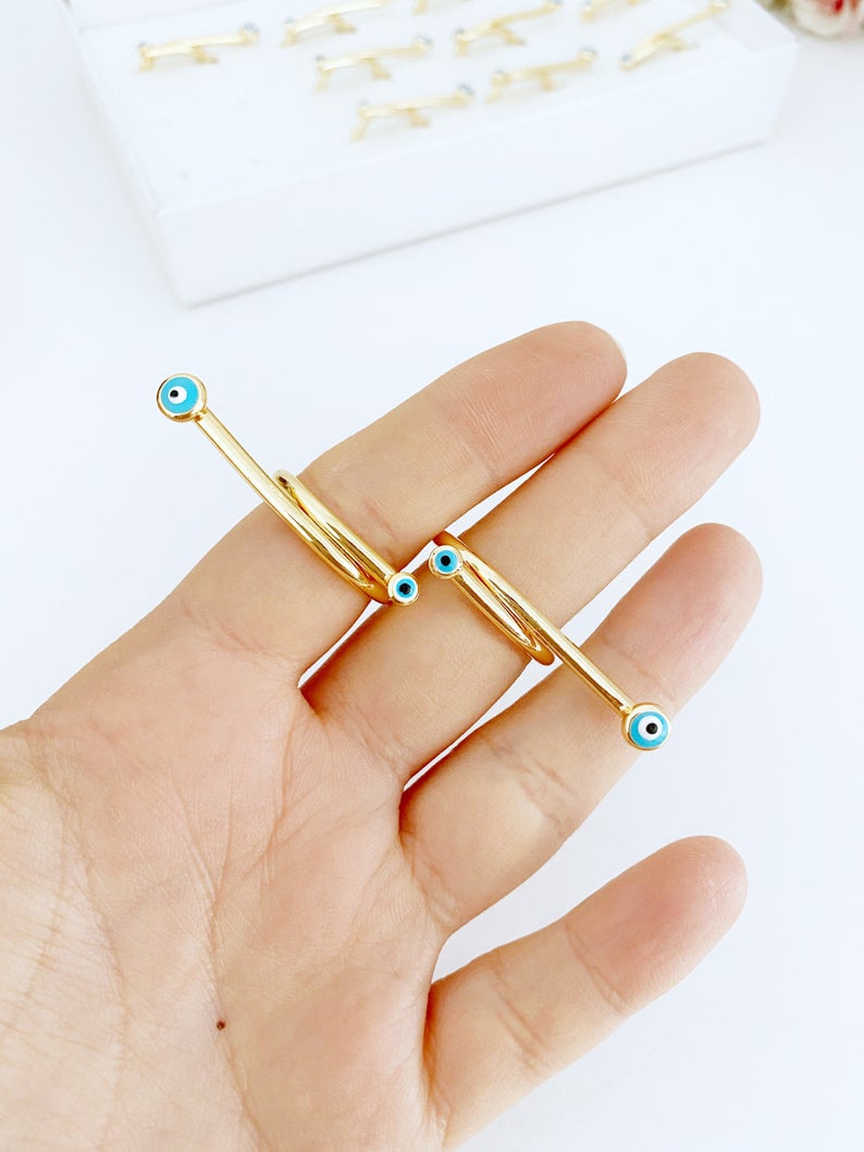 Adjustable Evil Eye Ring featuring a blue evil eye bead on a thin gold bar band, showcasing a minimalist and modern design.