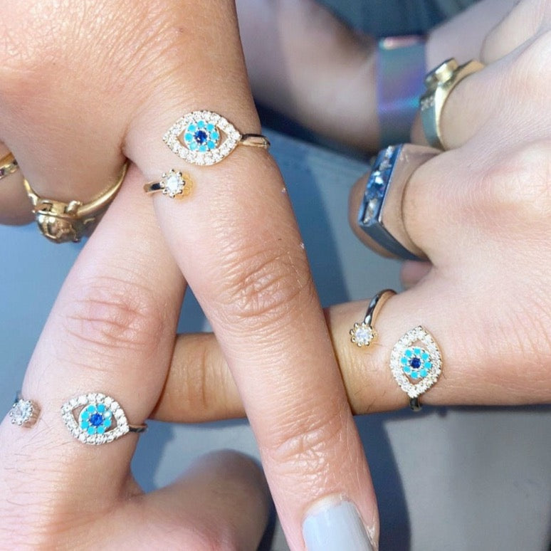 Evil Eye Ring featuring a blue eye design, available in gold, silver, and rose gold, adorned with zircon charms.