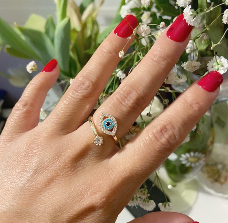 Evil Eye Ring featuring a blue eye design, available in gold, silver, and rose gold, adorned with zircon charms.