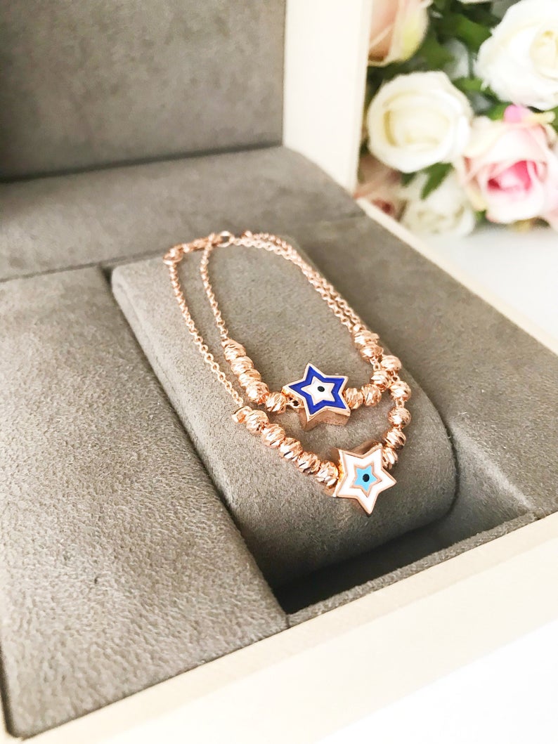 Evil Eye Star Bracelet featuring a rose gold bead chain with blue evil eye and star charm, handmade and adjustable.