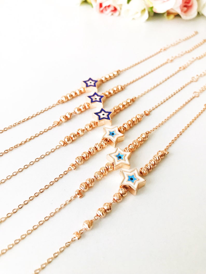 Evil Eye Star Bracelet featuring a rose gold bead chain with blue evil eye and star charm, handmade and adjustable.