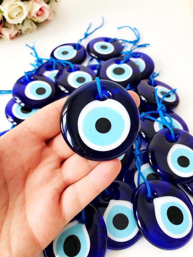 A beautiful blue evil eye wall hanging featuring glass beads, symbolizing protection and good luck, perfect for home decor.