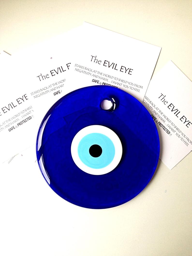 A beautiful blue evil eye wall hanging featuring glass beads, symbolizing protection and good luck, perfect for home decor.