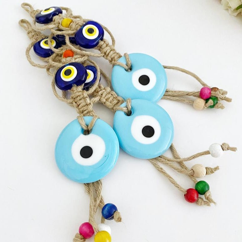 Handmade Evil Eye Wall Hanging featuring a large blue evil eye bead and macrame design, symbolizing protection and good luck.