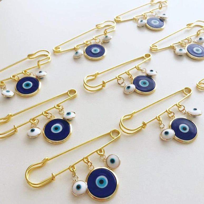 Evil Eye Wedding Favor featuring a blue Murano bead and gold plated safety pin, adorned with white glass evil eye beads.