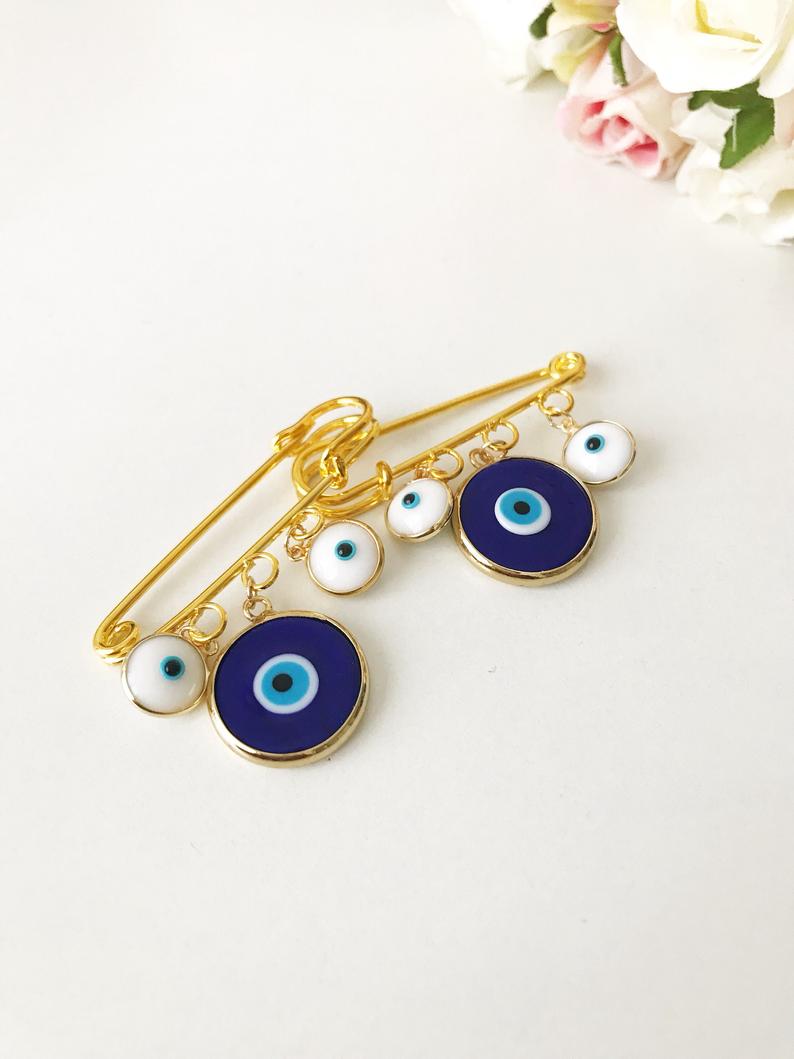 Evil Eye Wedding Favor featuring a blue Murano bead and gold plated safety pin, adorned with white glass evil eye beads.