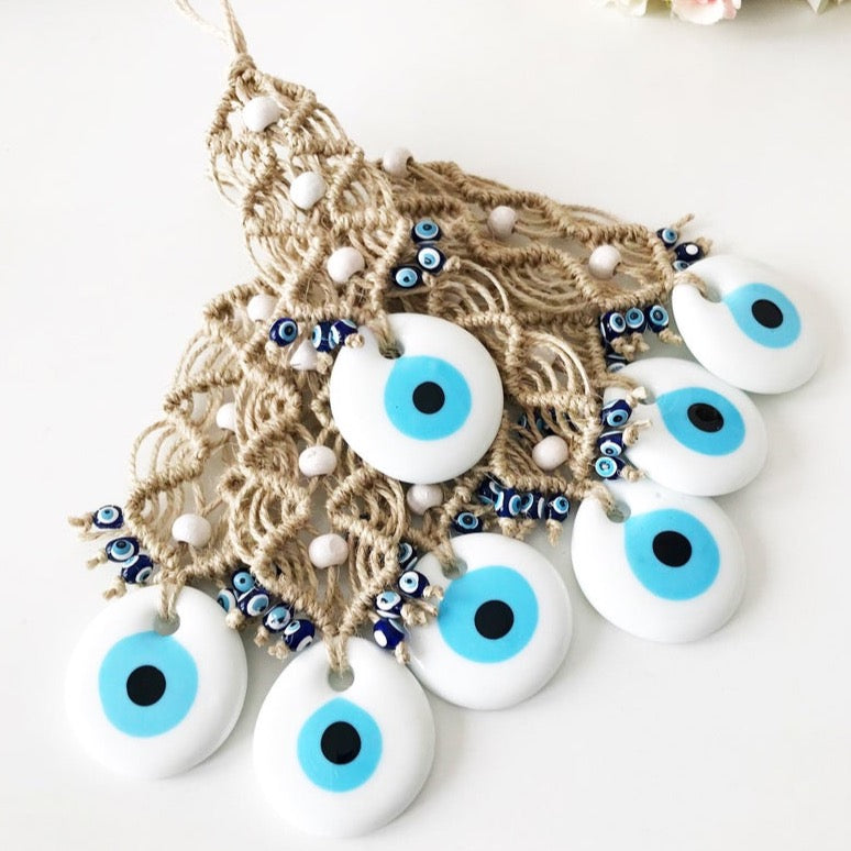 A beautiful display of 10 white evil eye beads with macrame decor, perfect for wedding favors and wall hanging.