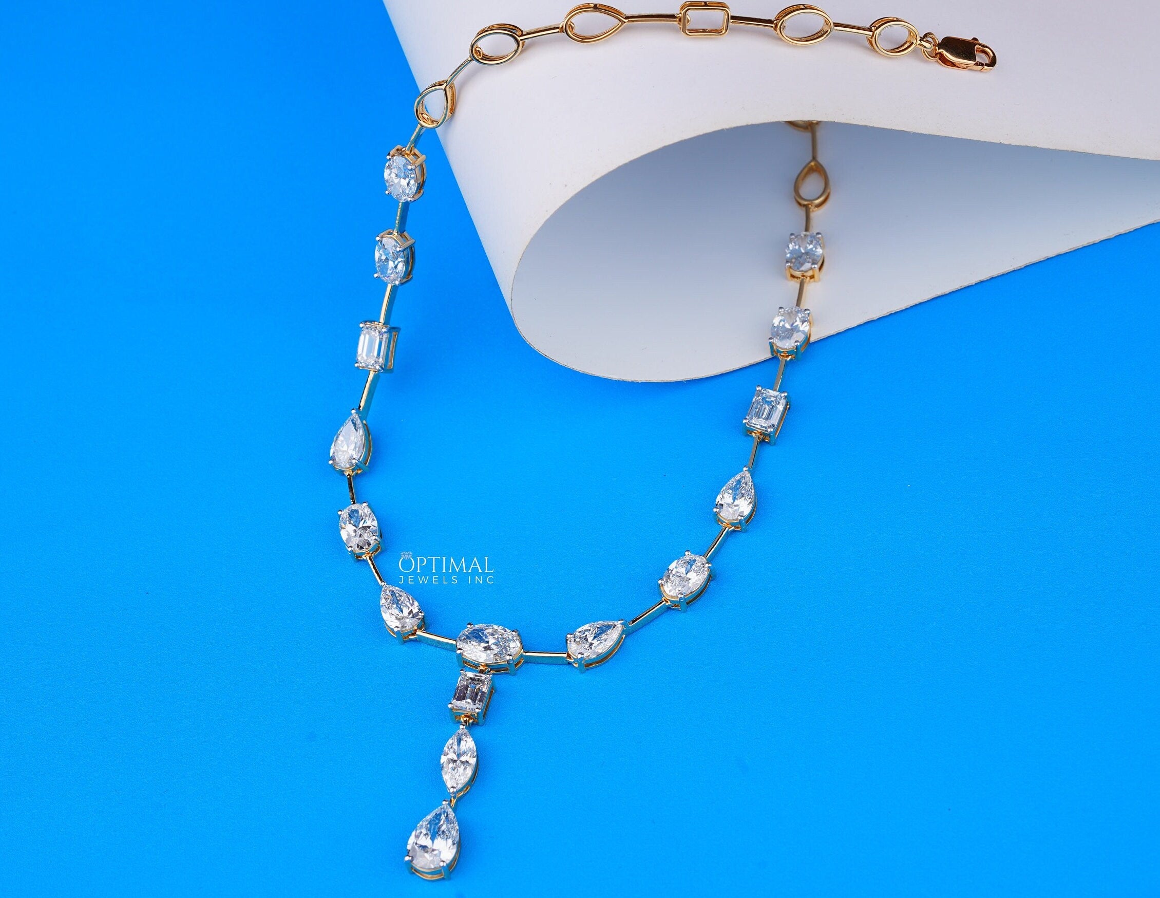 Exquisite gold necklace featuring pear, oval, and rectangular cut lab-grown diamonds in a central drop design.