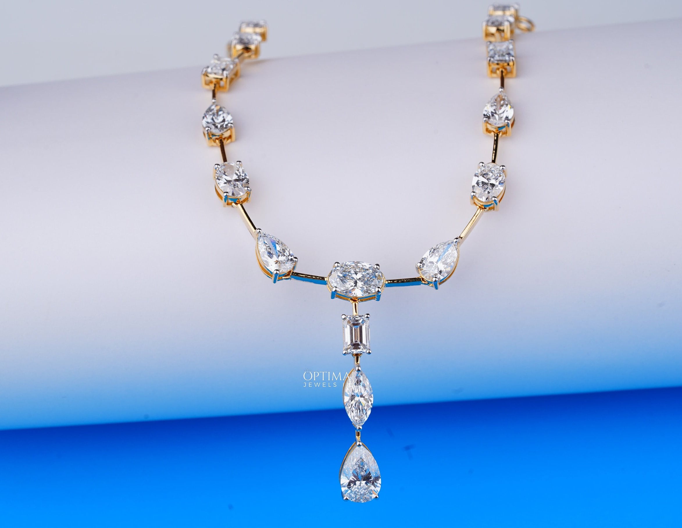 Exquisite gold necklace featuring pear, oval, and rectangular cut lab-grown diamonds in a central drop design.