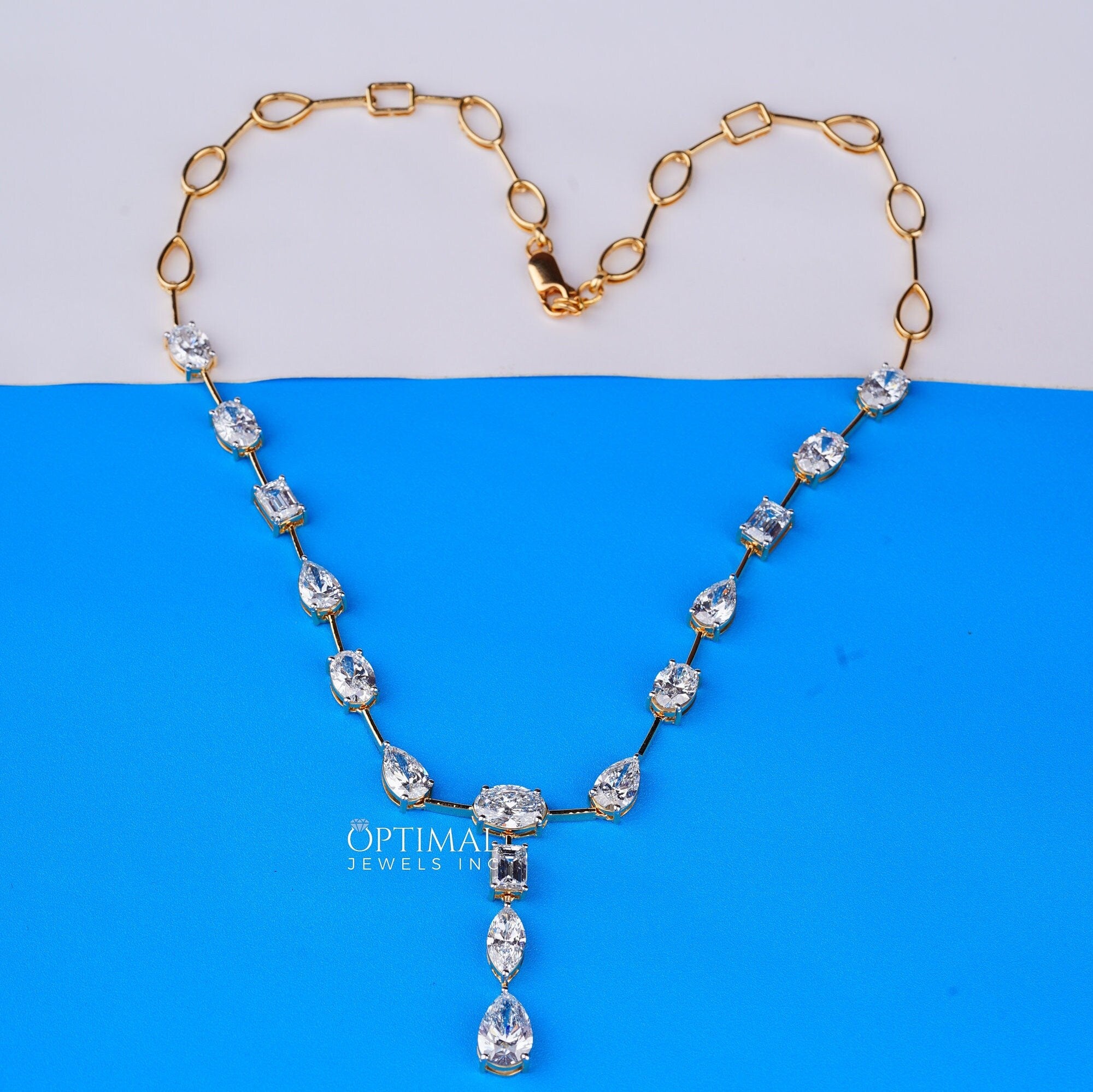 Exquisite gold necklace featuring pear, oval, and rectangular cut lab-grown diamonds in a central drop design.
