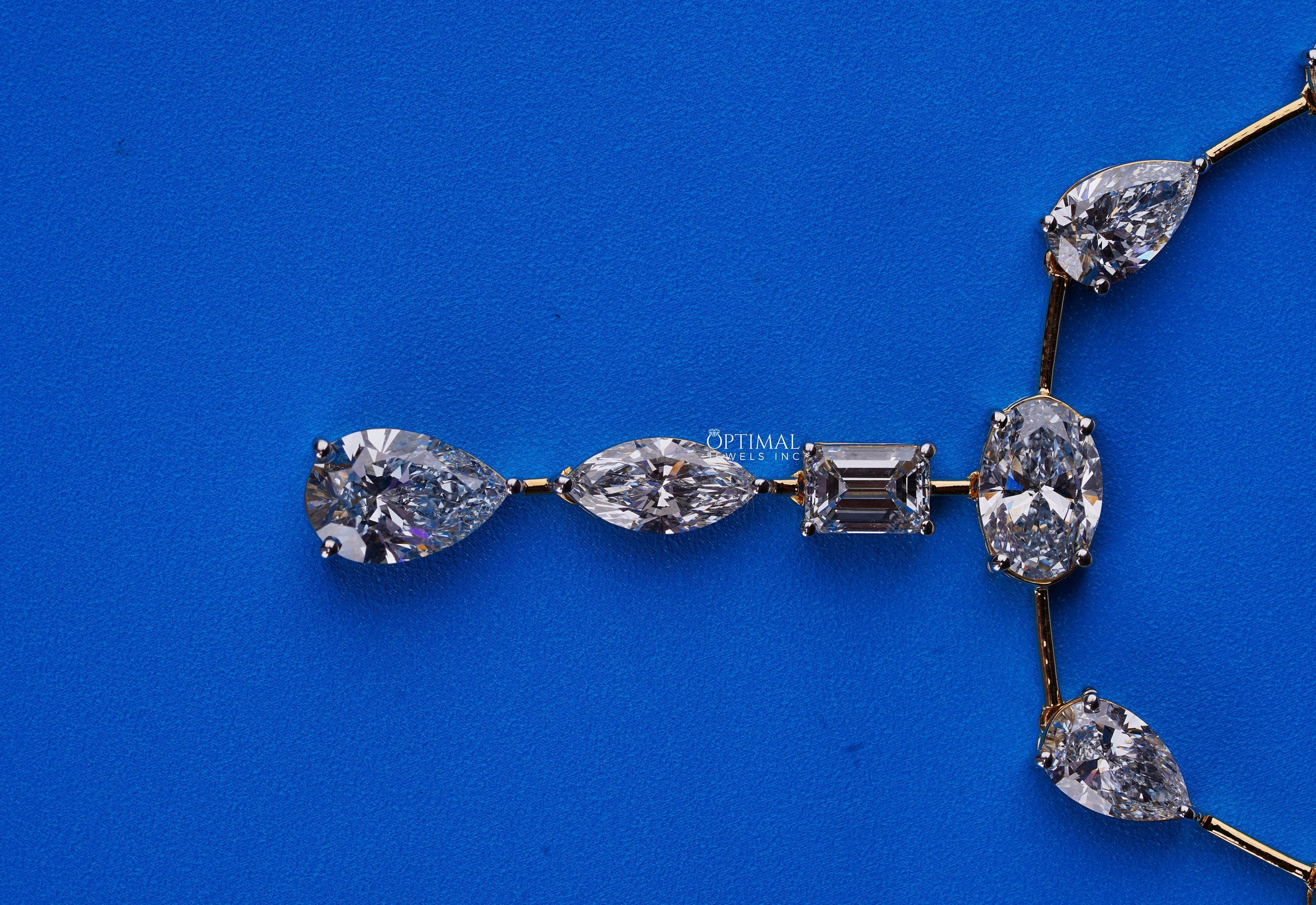 Exquisite gold necklace featuring pear, oval, and rectangular cut lab-grown diamonds in a central drop design.