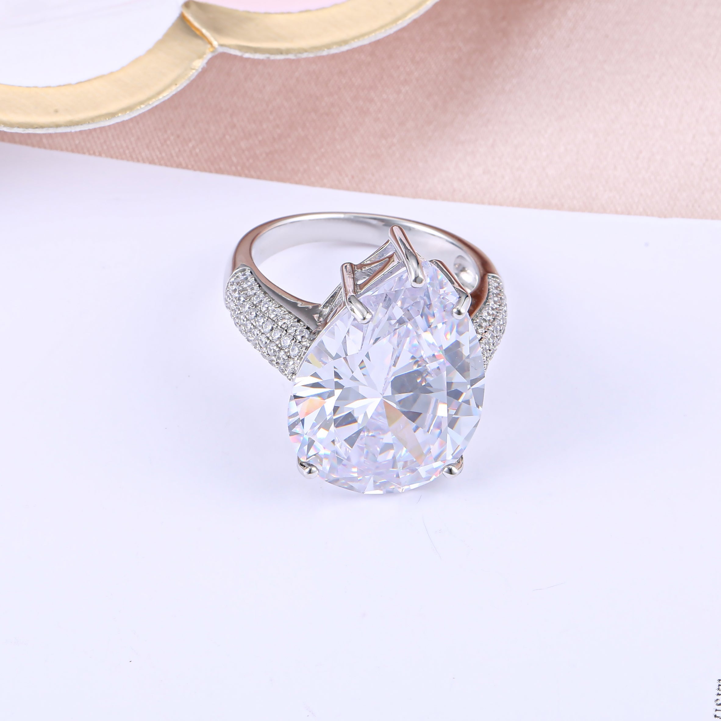 An extraordinary white sapphire engagement ring featuring a pear-shaped stone set in 925 sterling silver with a real white gold finish.