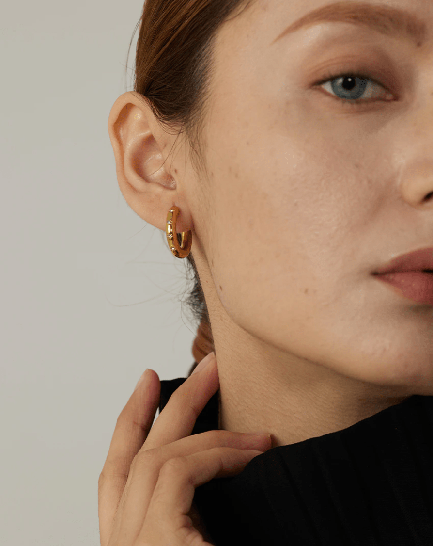 Faith Starburst Round Gold Huggies featuring stardust clear crystals on a polished round design, perfect for everyday wear.