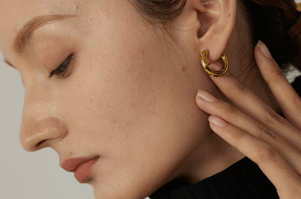 Faith Starburst Round Gold Huggies featuring stardust clear crystals on a polished round design, perfect for everyday wear.