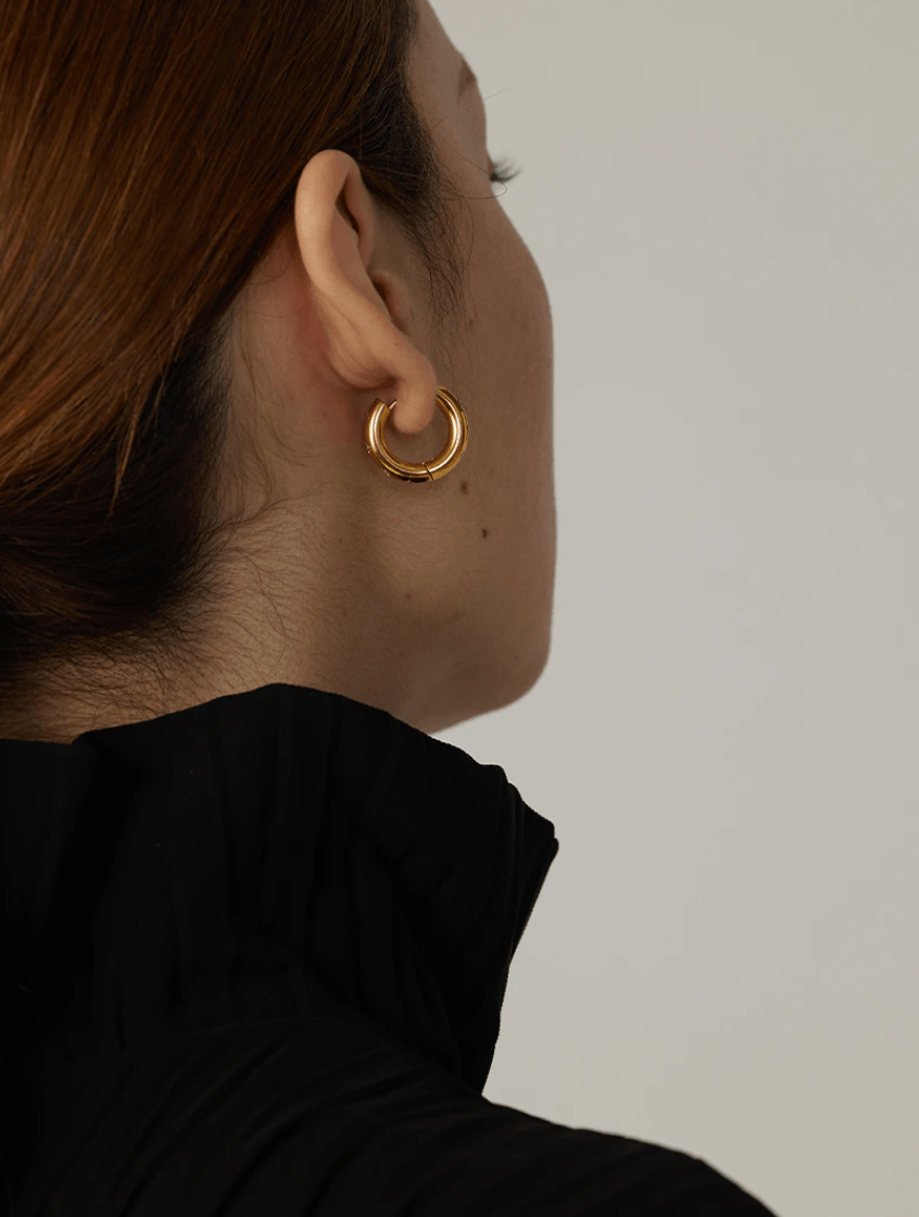 Faith Starburst Round Gold Huggies featuring stardust clear crystals on a polished round design, perfect for everyday wear.