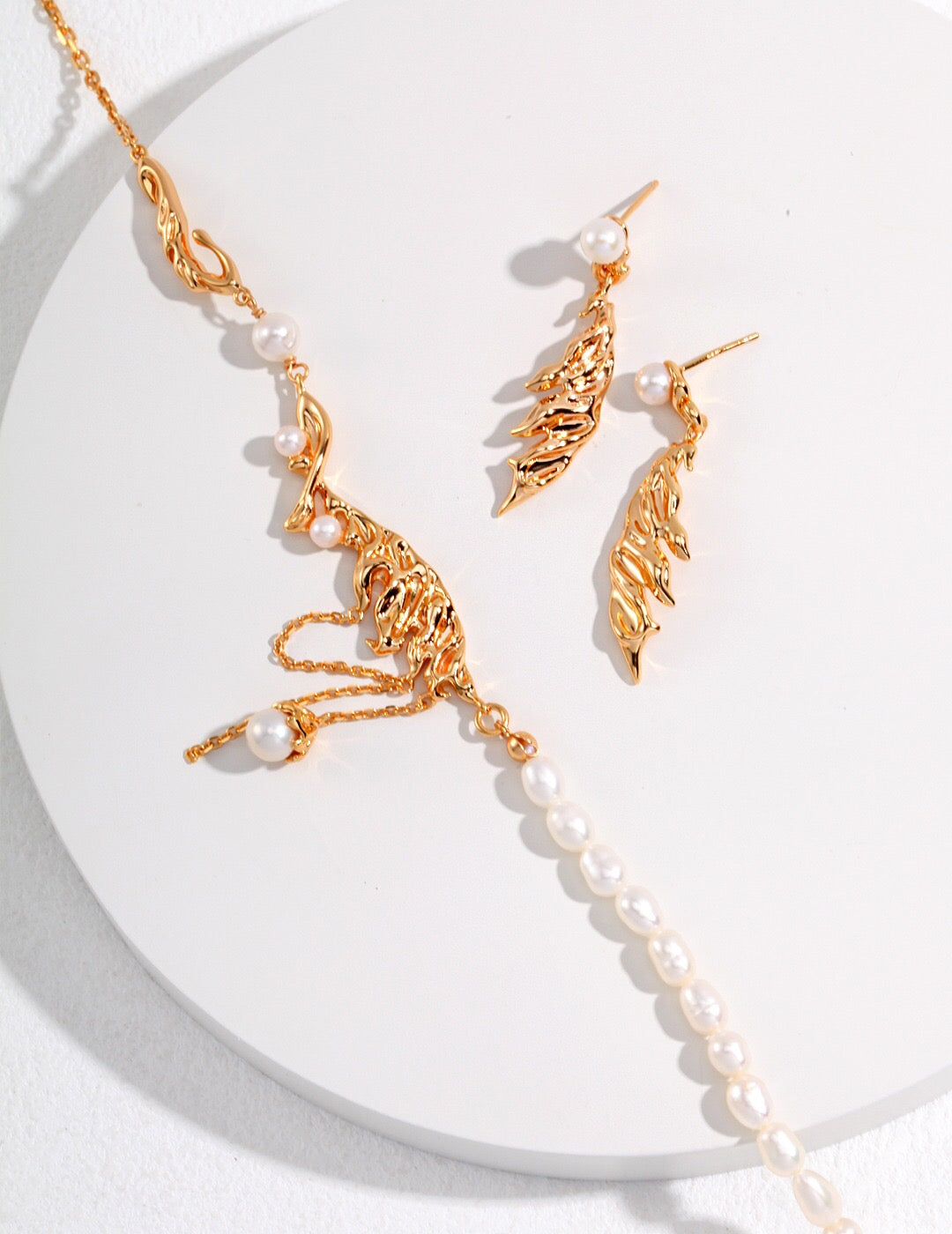 Elegant Feather Style Pearl Pendant Necklace featuring natural pearls and gold vermeil plating, displayed on a soft fabric background.