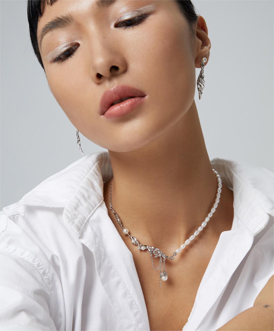 Elegant Feather Style Pearl Pendant Necklace featuring natural pearls and gold vermeil plating, displayed on a soft fabric background.