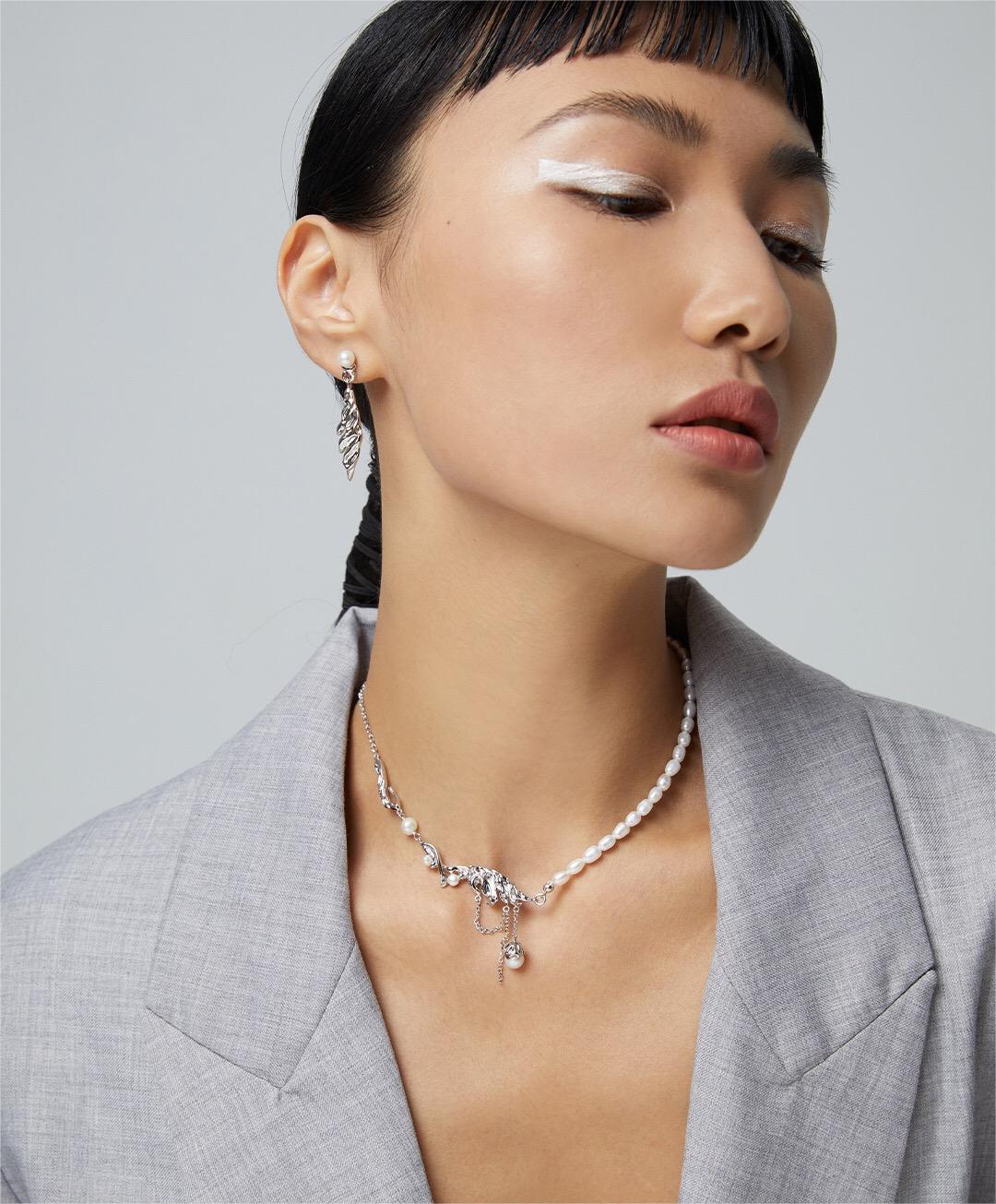 Elegant Feather Style Pearl Pendant Necklace featuring natural pearls and gold vermeil plating, displayed on a soft fabric background.