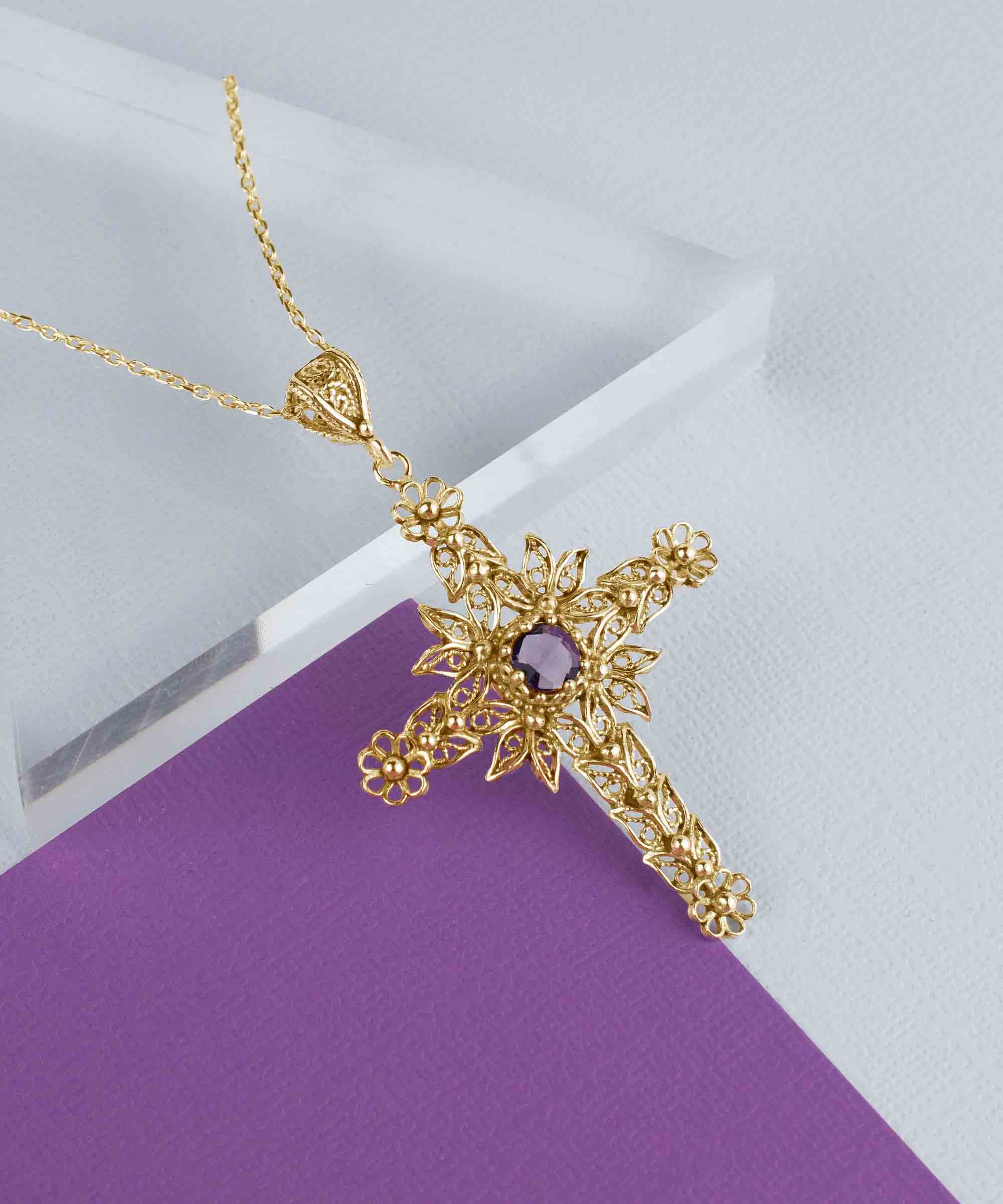 Gold plated silver cross pendant featuring intricate filigree art and a beautiful Amethyst gemstone, perfect for women.