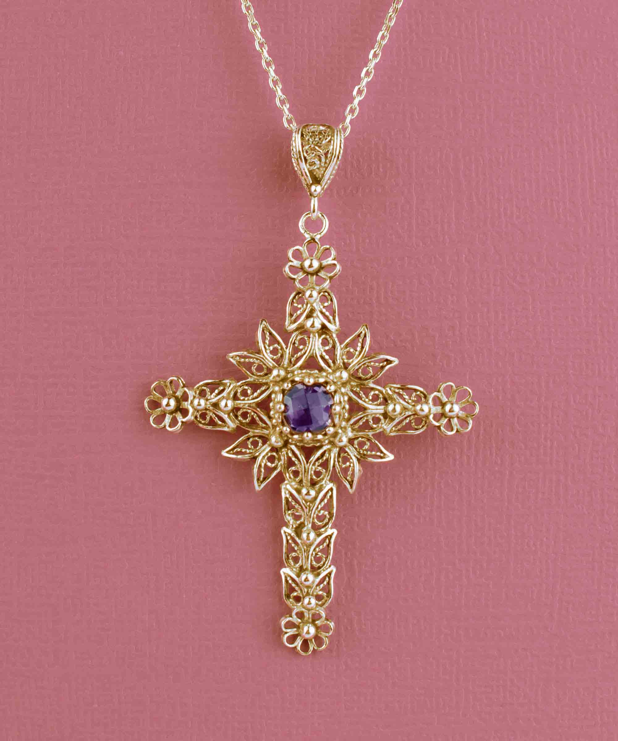 Gold plated silver cross pendant featuring intricate filigree art and a beautiful Amethyst gemstone, perfect for women.