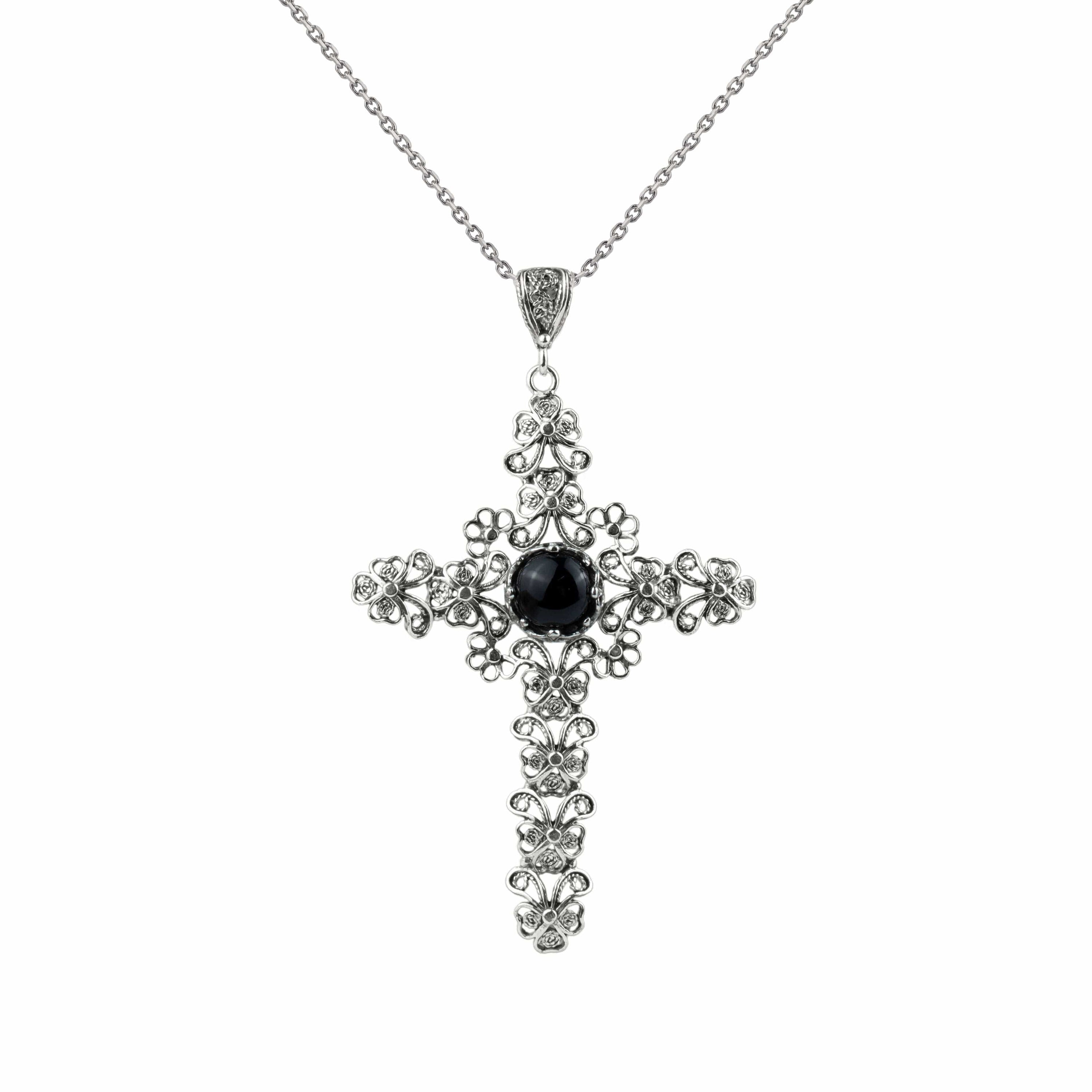 Elegant sterling silver filigree cross pendant featuring a black onyx gemstone, showcasing intricate craftsmanship and design.