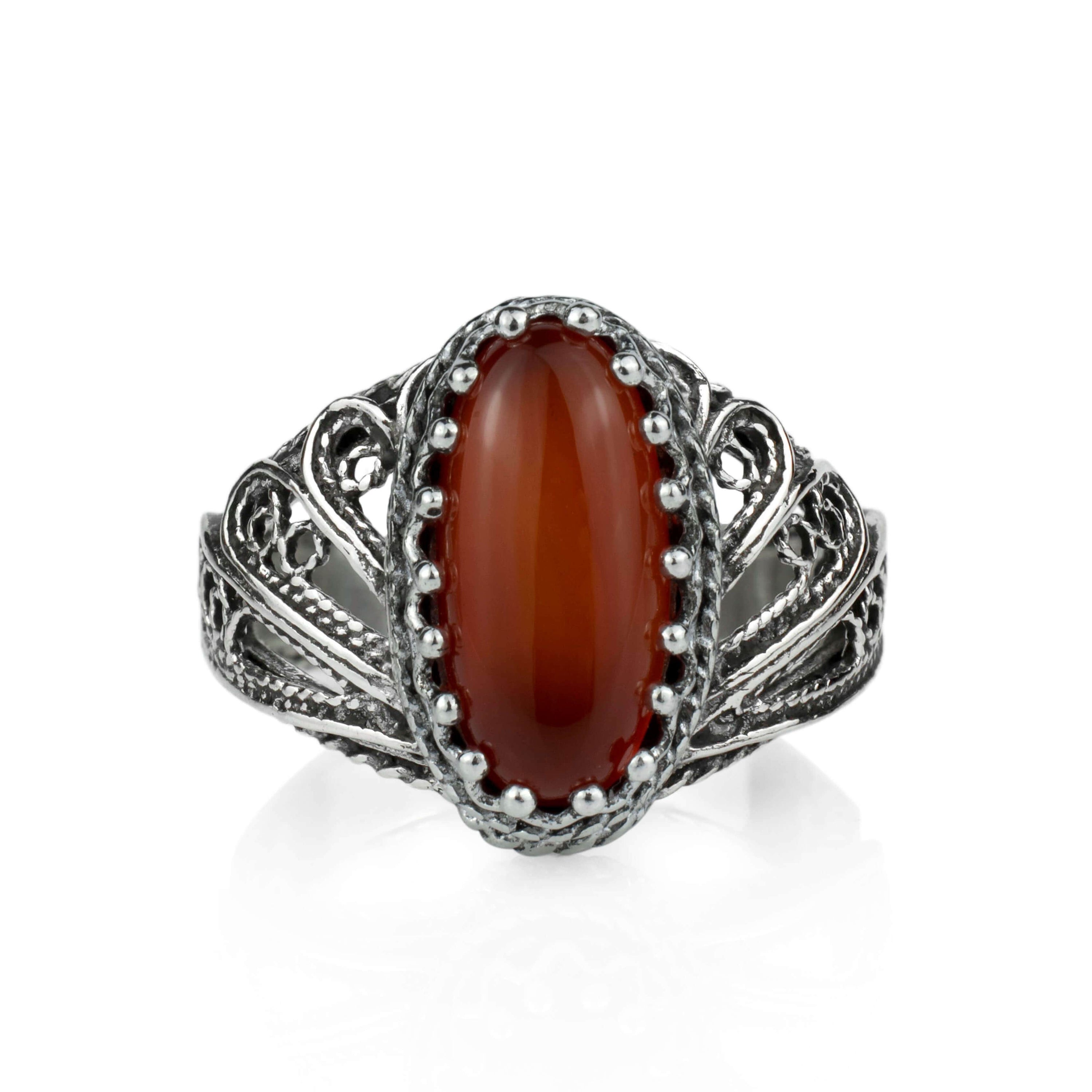 Elegant silver cocktail ring featuring filigree art design and a carnelian gemstone in an angel wings setting.
