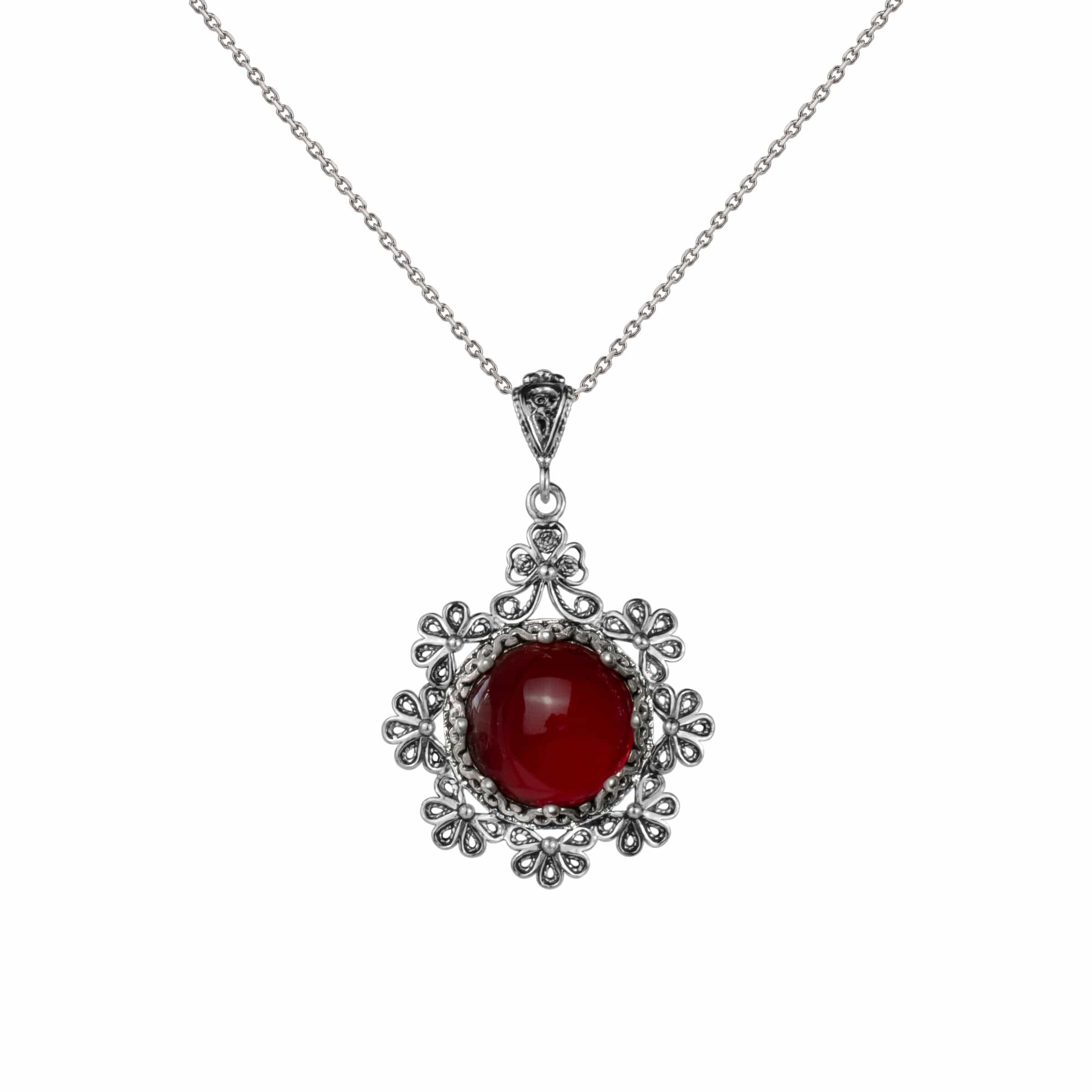 Sterling silver filigree pendant featuring a round cut carnelian gemstone in a floral design, showcasing intricate metalwork.
