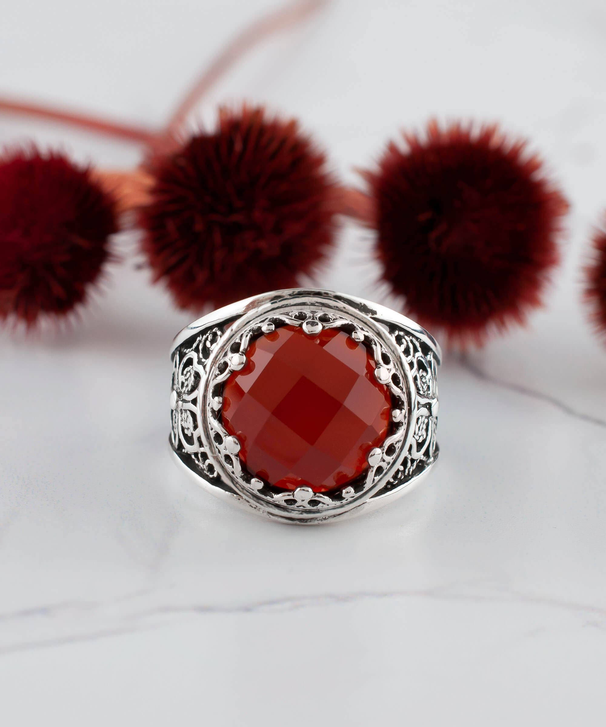 A stunning sterling silver filigree ring featuring a round, faceted rose-cut carnelian gemstone, elegantly designed for women.