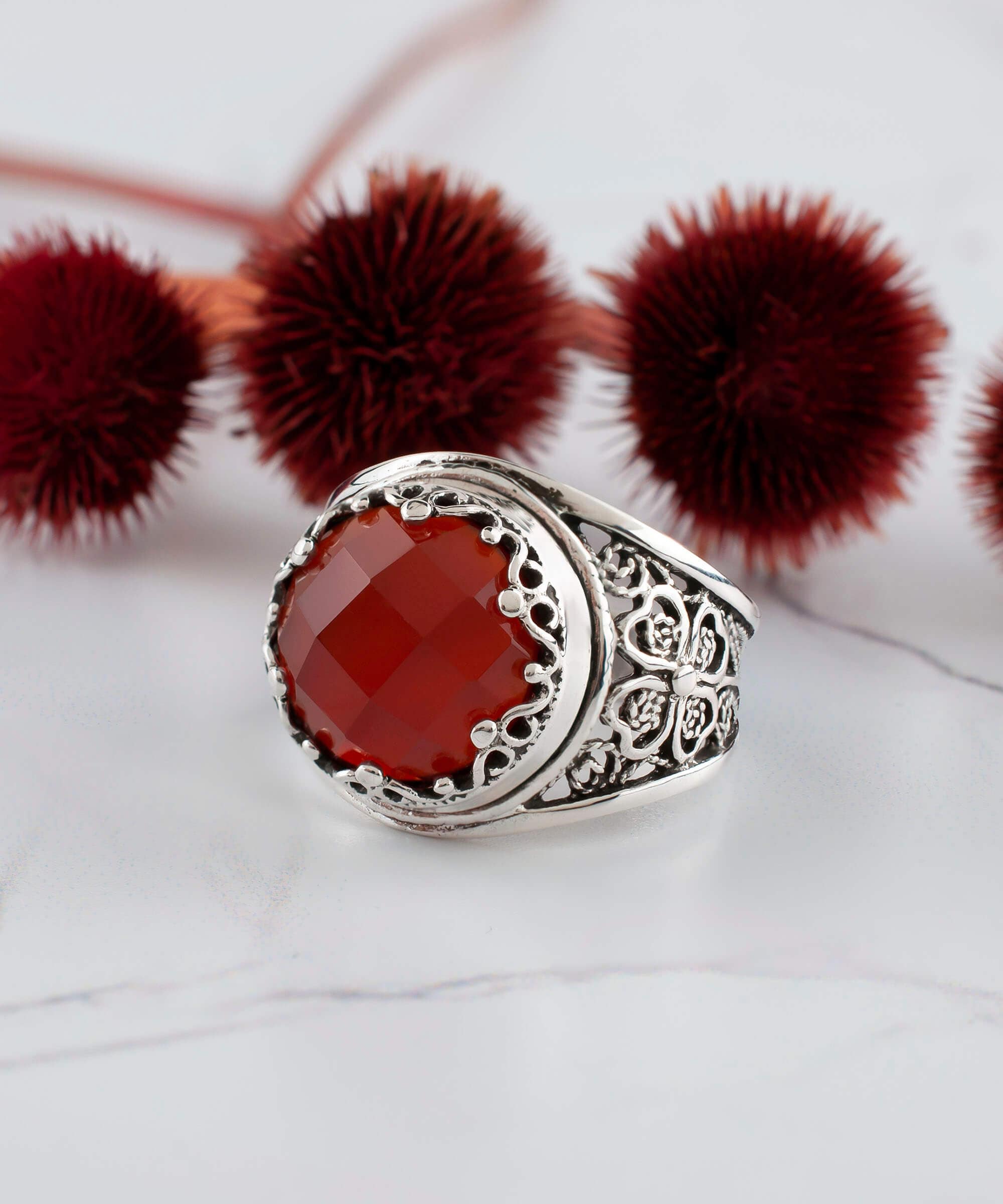 A stunning sterling silver filigree ring featuring a round, faceted rose-cut carnelian gemstone, elegantly designed for women.
