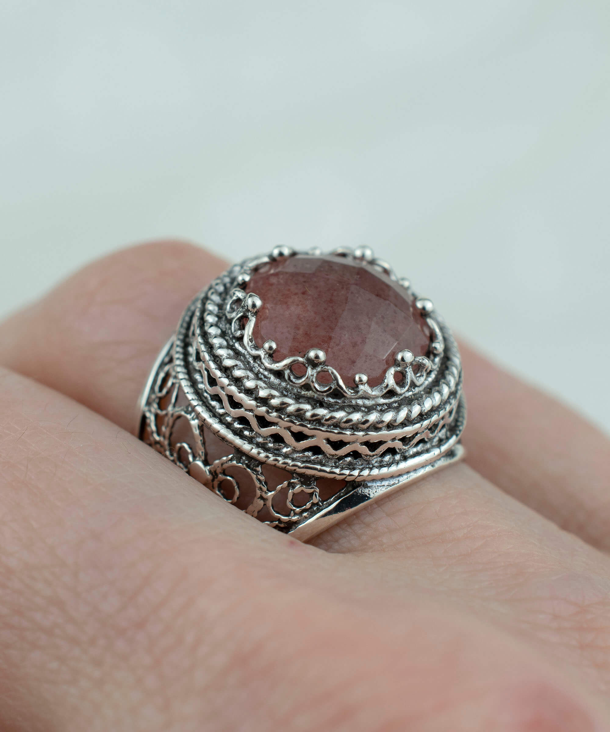 A stunning sterling silver bold ring featuring a cherry quartz gemstone with intricate filigree art design, showcasing a blend of traditional and modern craftsmanship.