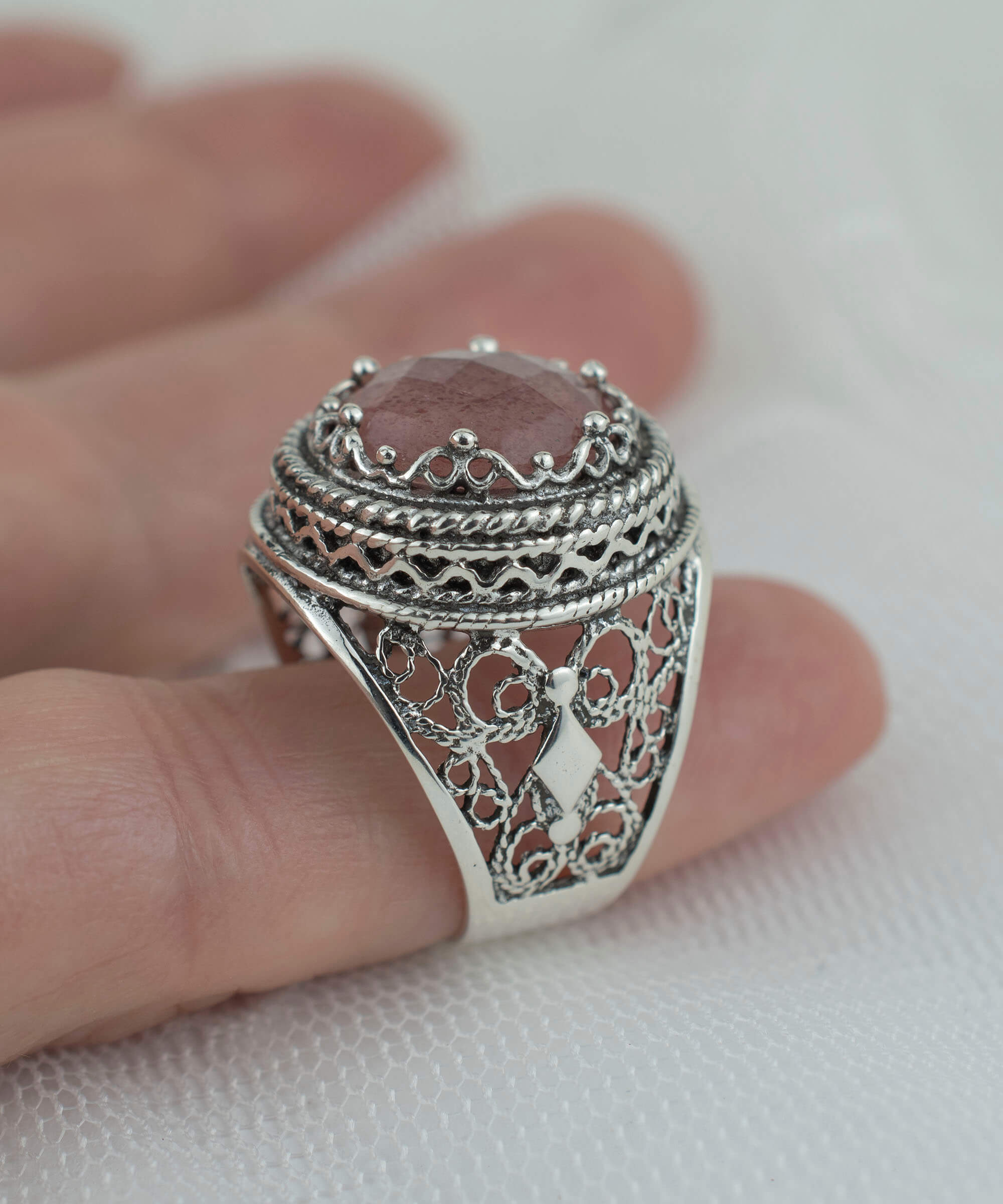 A stunning sterling silver bold ring featuring a cherry quartz gemstone with intricate filigree art design, showcasing a blend of traditional and modern craftsmanship.