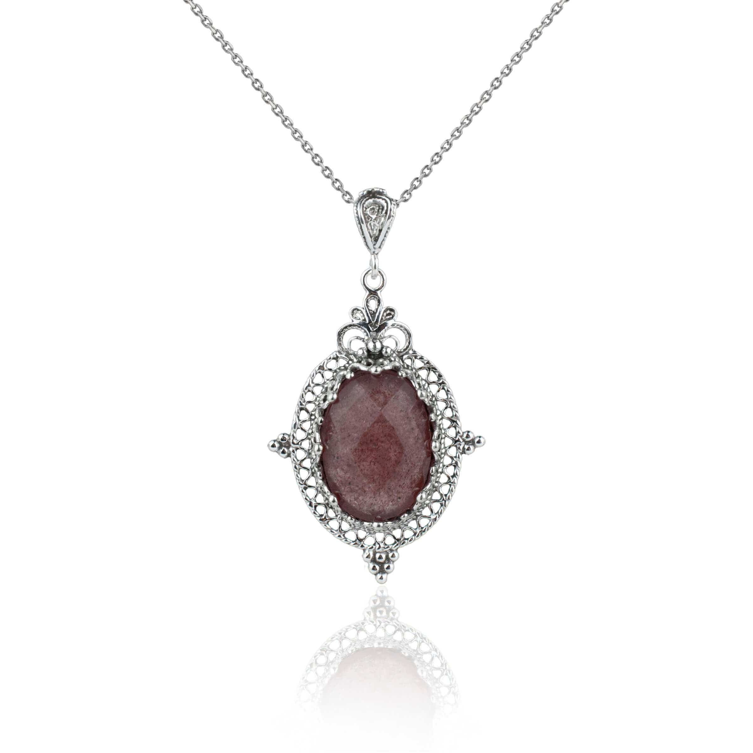 Elegant silver oval pendant necklace featuring filigree art and a cherry quartz gemstone, showcasing intricate craftsmanship.