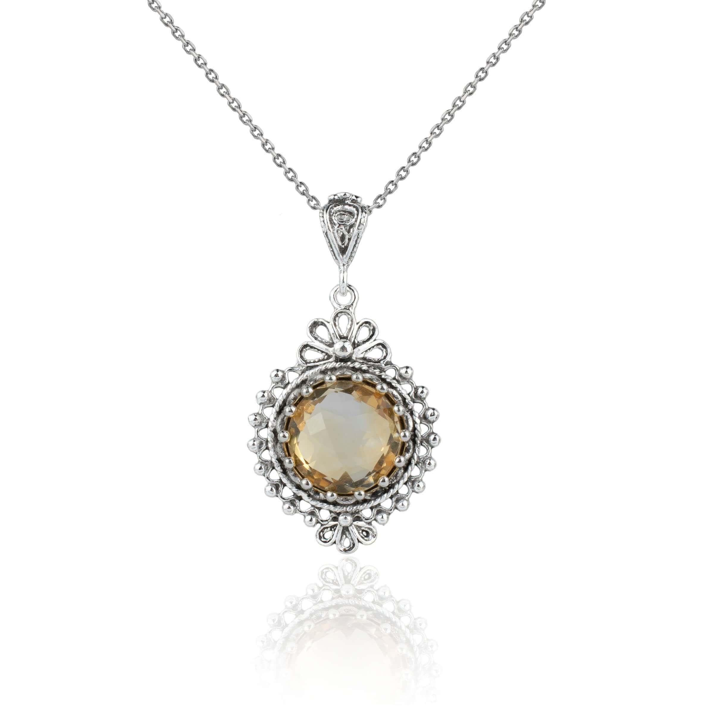Elegant silver boho pendant necklace featuring a filigree design and a round-cut citrine gemstone.