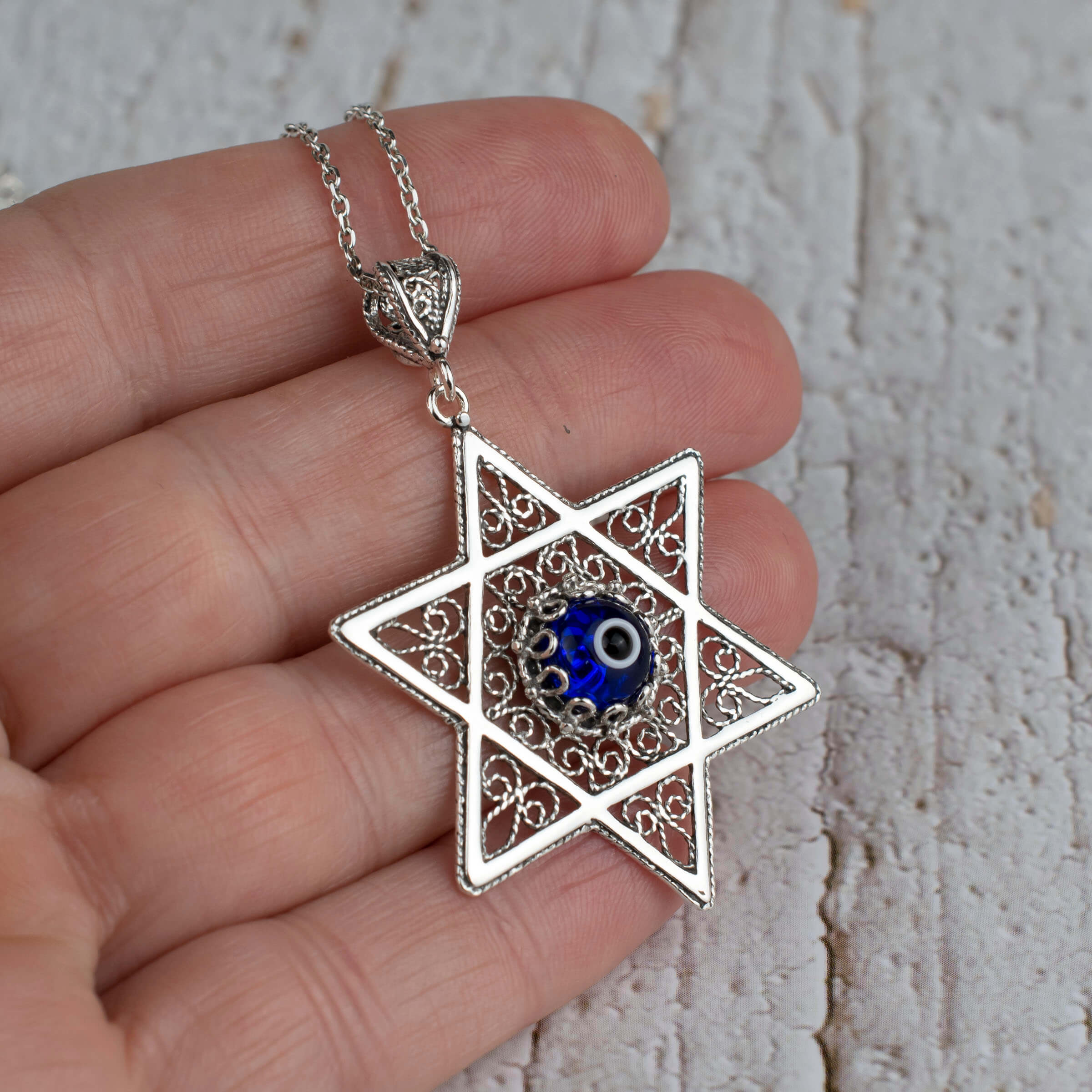Sterling silver filigree art pendant featuring an Evil Eye stone and Star of David design, elegantly crafted for women.