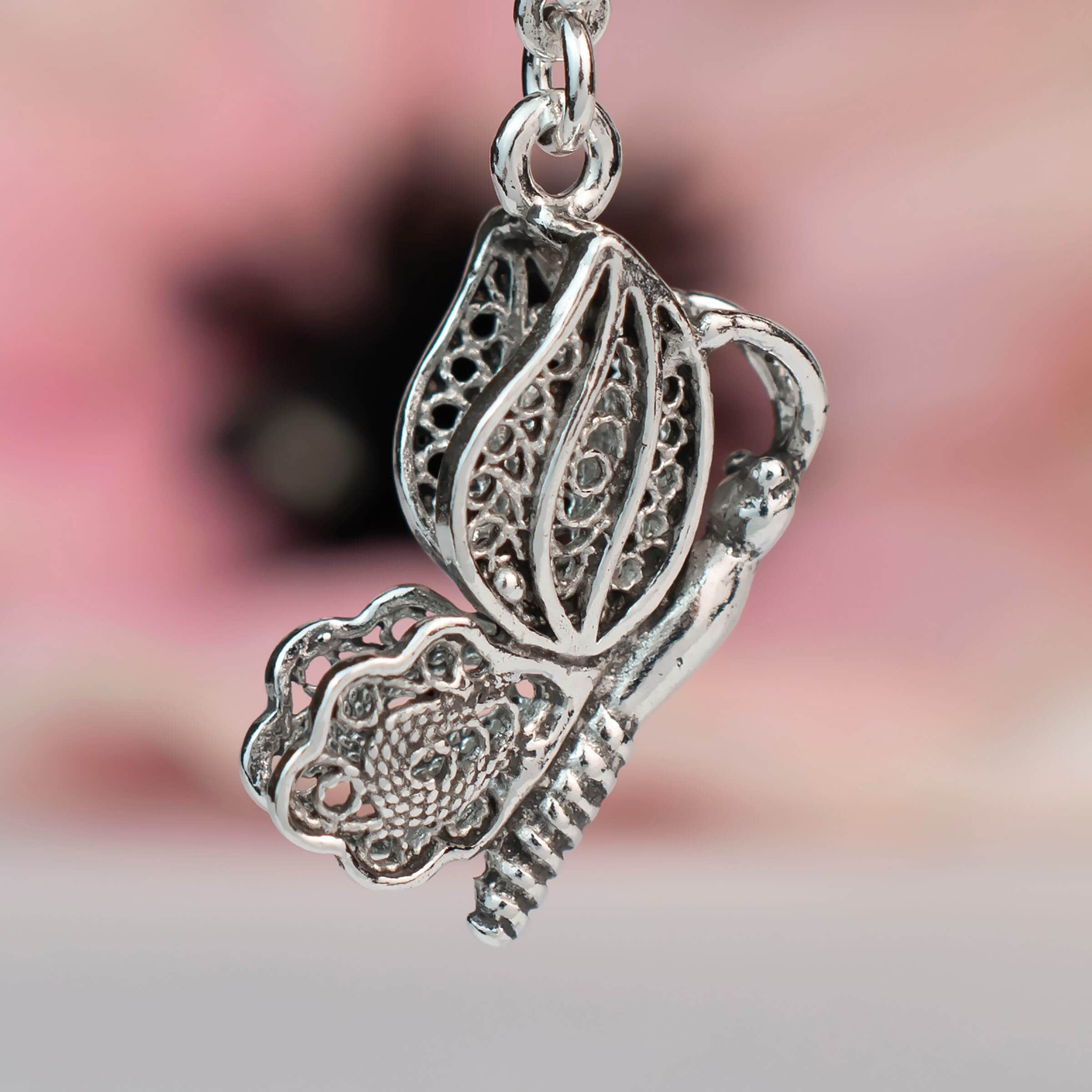 Elegant silver dangle drop earrings featuring a filigree butterfly design, handcrafted from 925 sterling silver.