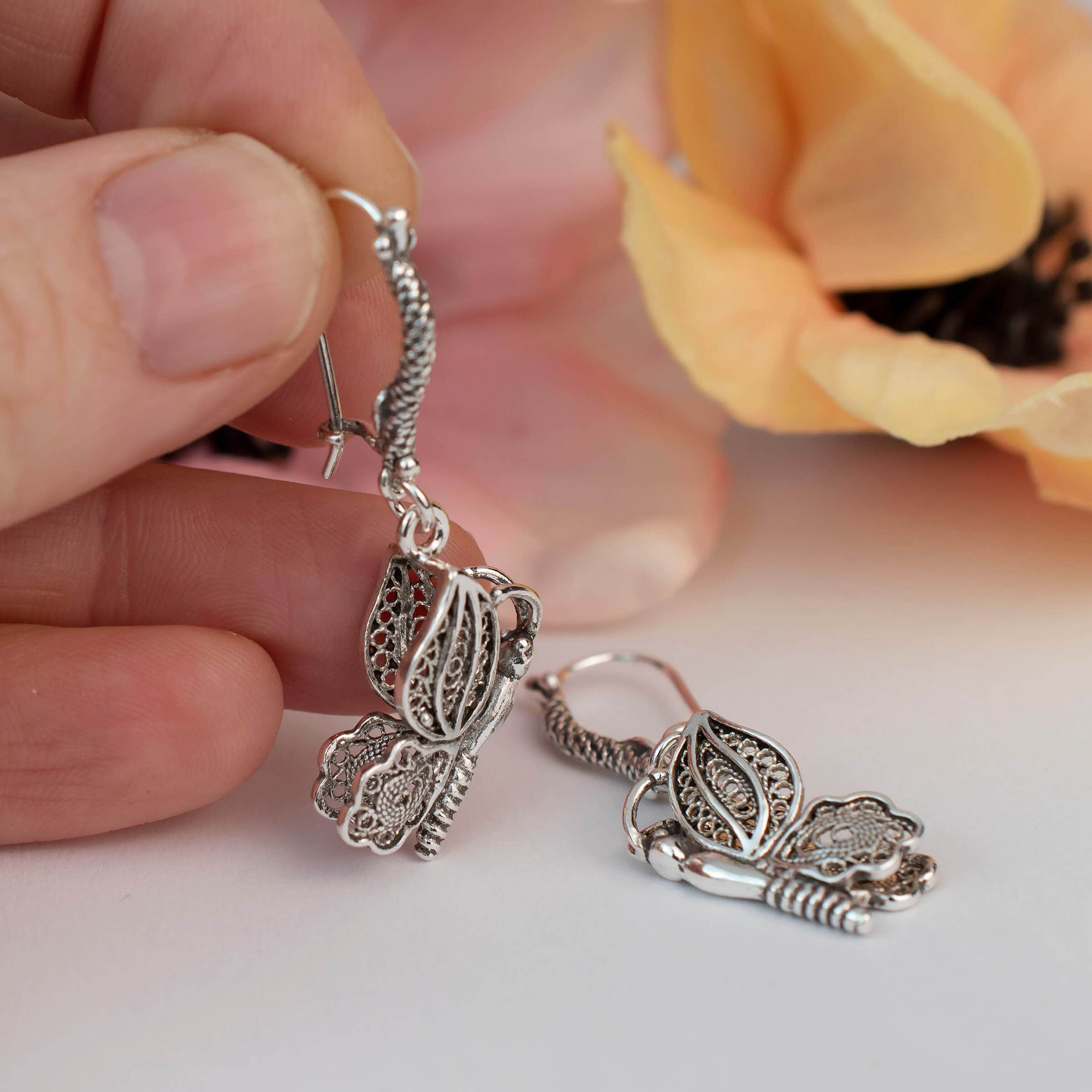 Elegant silver dangle drop earrings featuring a filigree butterfly design, handcrafted from 925 sterling silver.