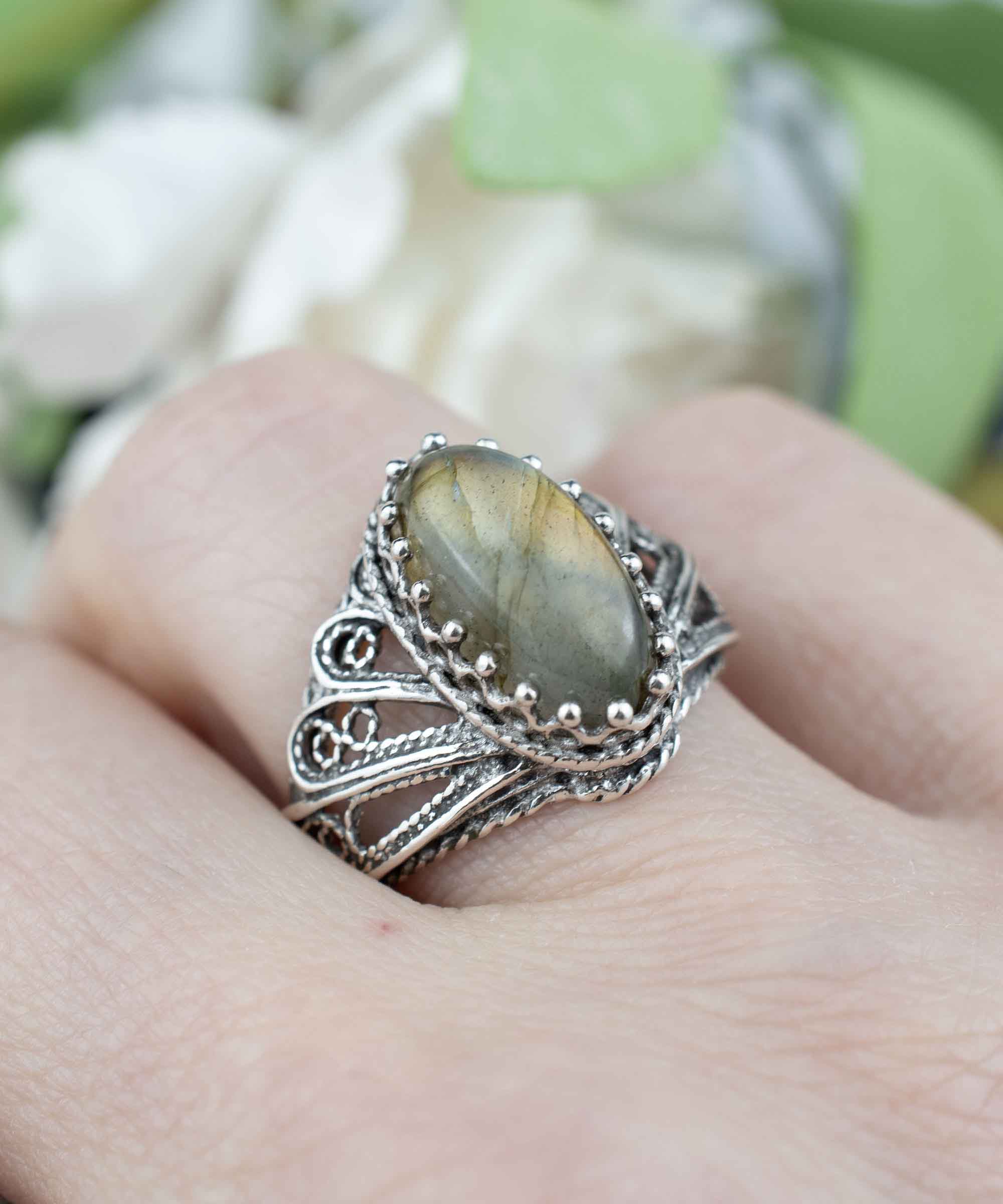 Elegant silver cocktail ring featuring a labradorite gemstone in an angel wings filigree design, crafted from 925 sterling silver.