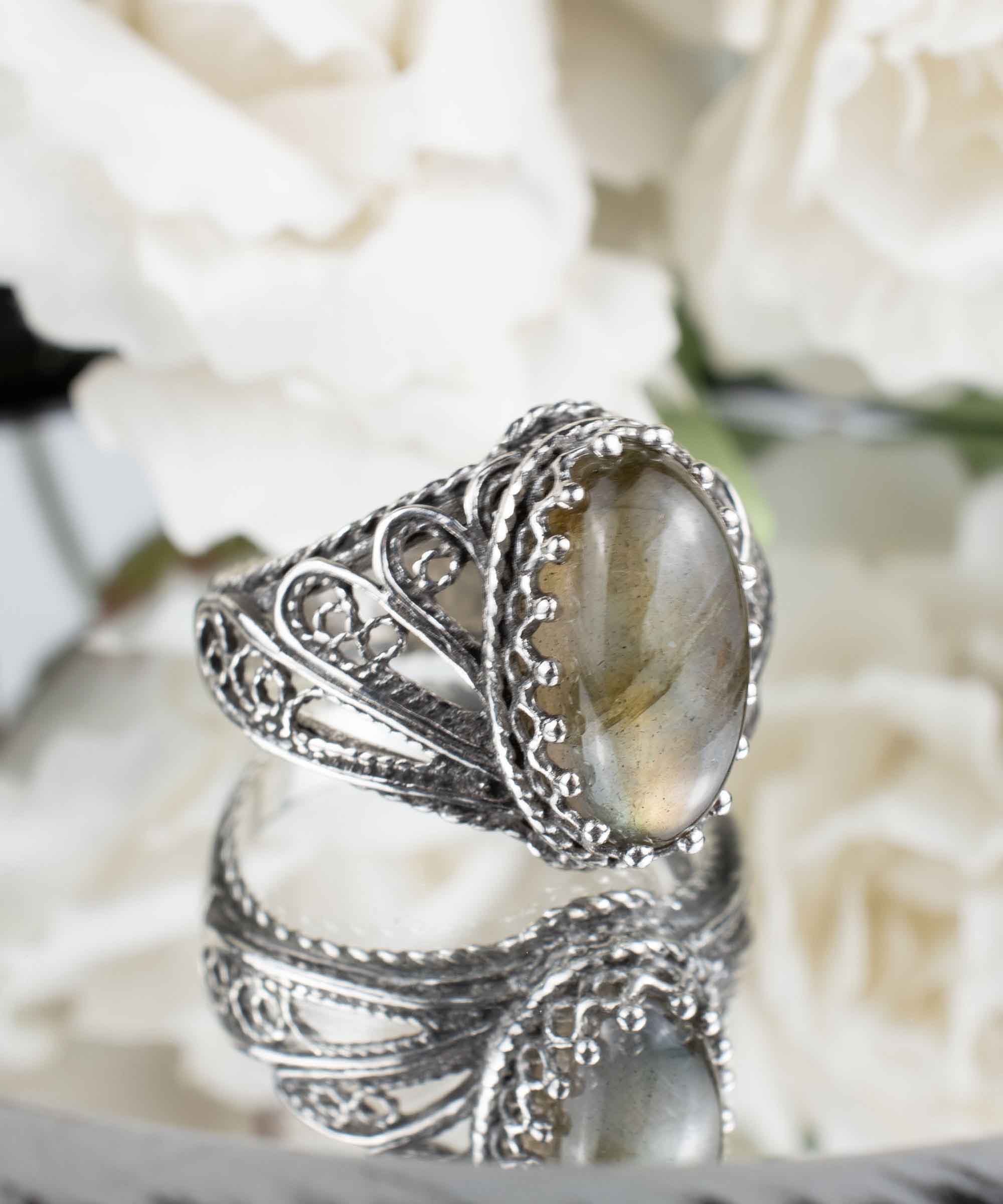 Elegant silver cocktail ring featuring a labradorite gemstone in an angel wings filigree design, crafted from 925 sterling silver.