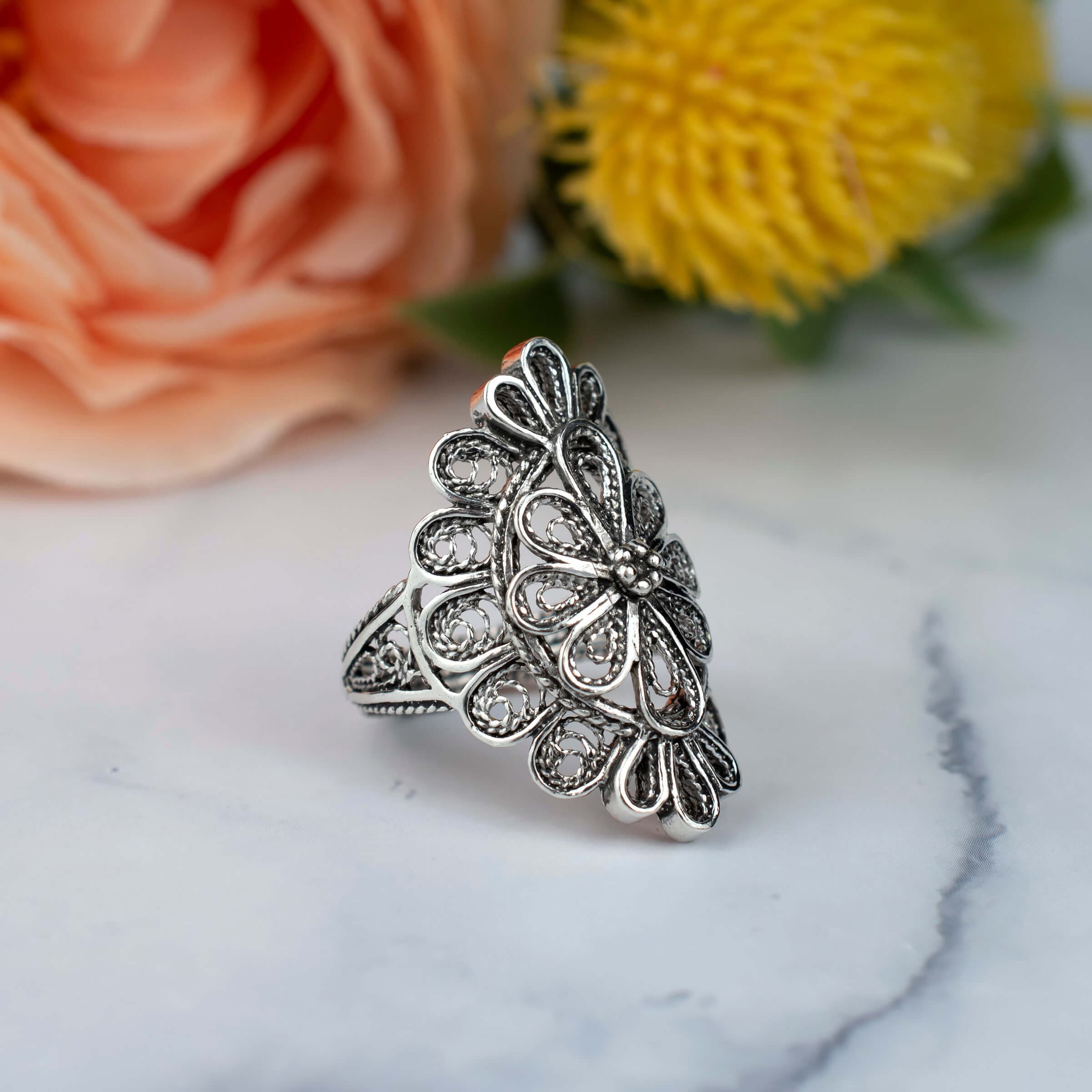 A stunning long statement ring made of sterling silver featuring intricate filigree lace detailing, showcasing a blend of traditional and modern artistry.