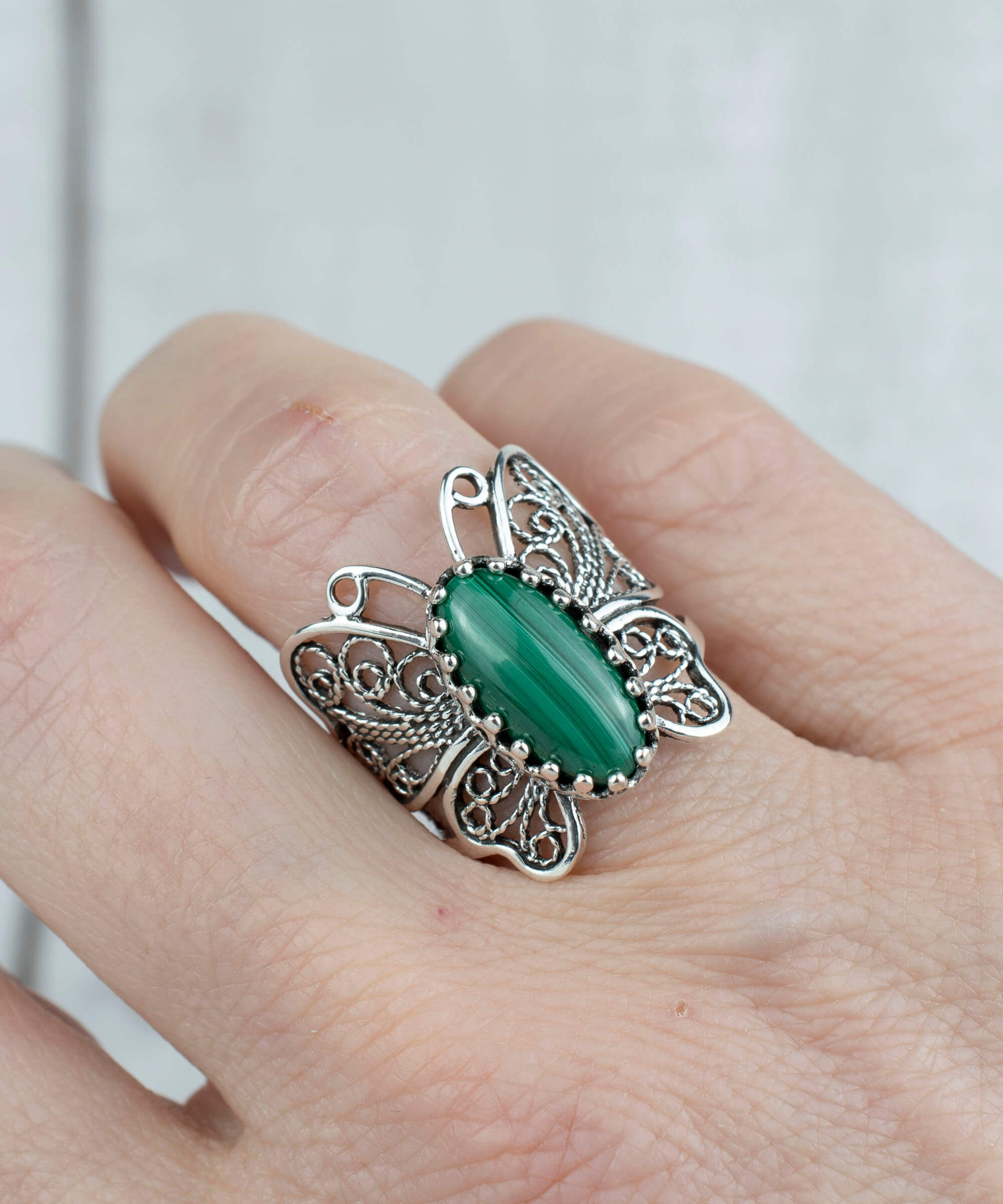 Sterling silver filigree butterfly cocktail ring featuring a malachite gemstone, elegantly designed with intricate details.