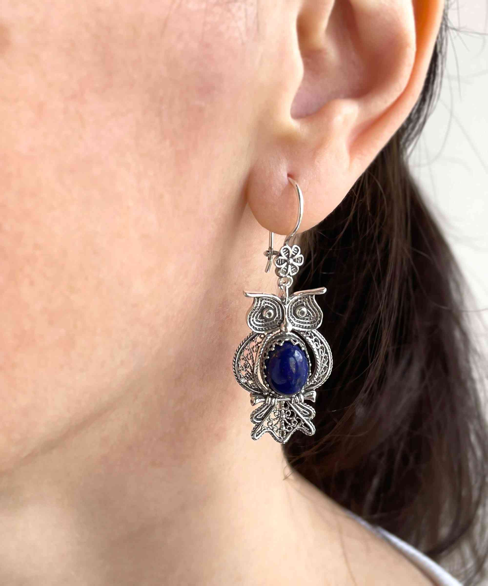 Elegant silver dangle earrings featuring owl design and Lapis Lazuli gemstone, showcasing intricate filigree craftsmanship.