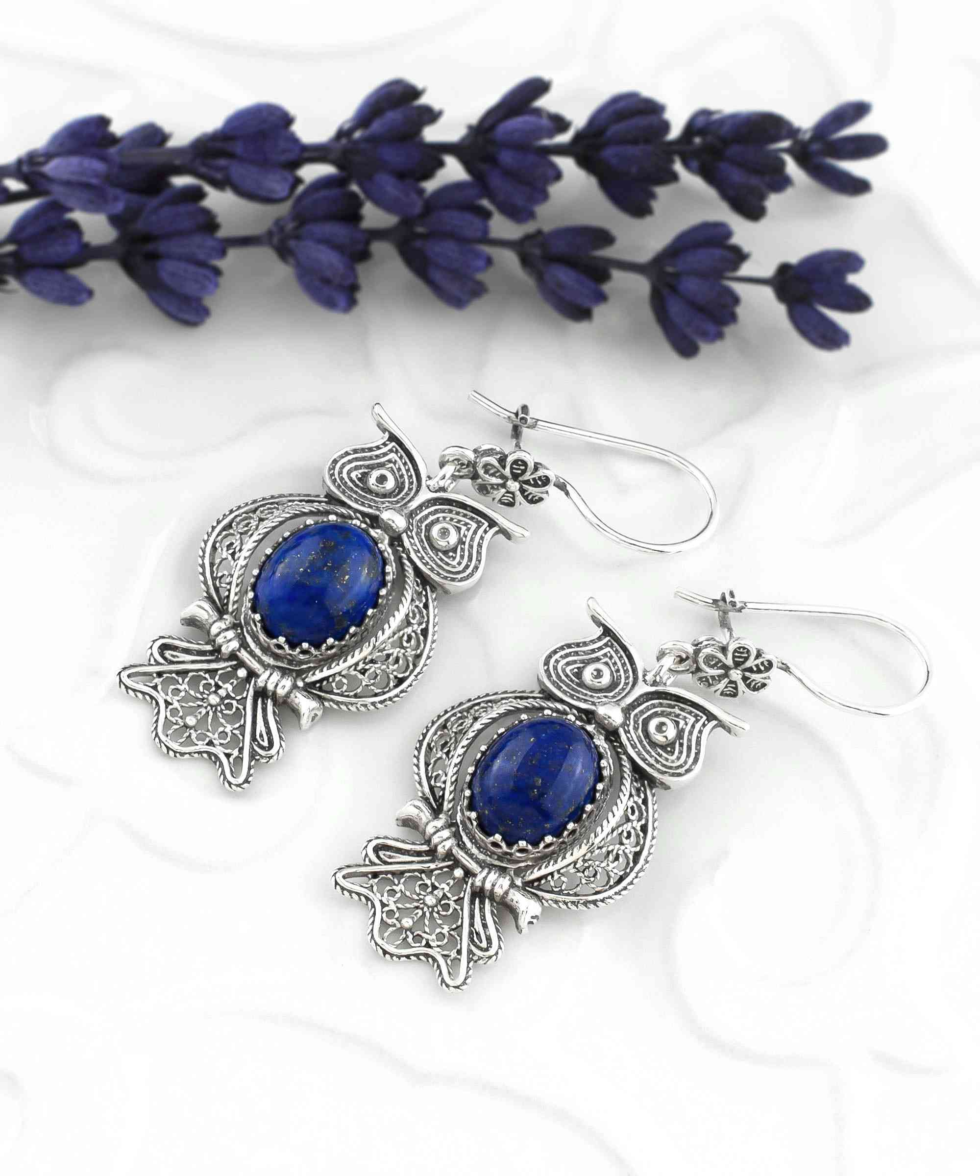 Elegant silver dangle earrings featuring owl design and Lapis Lazuli gemstone, showcasing intricate filigree craftsmanship.