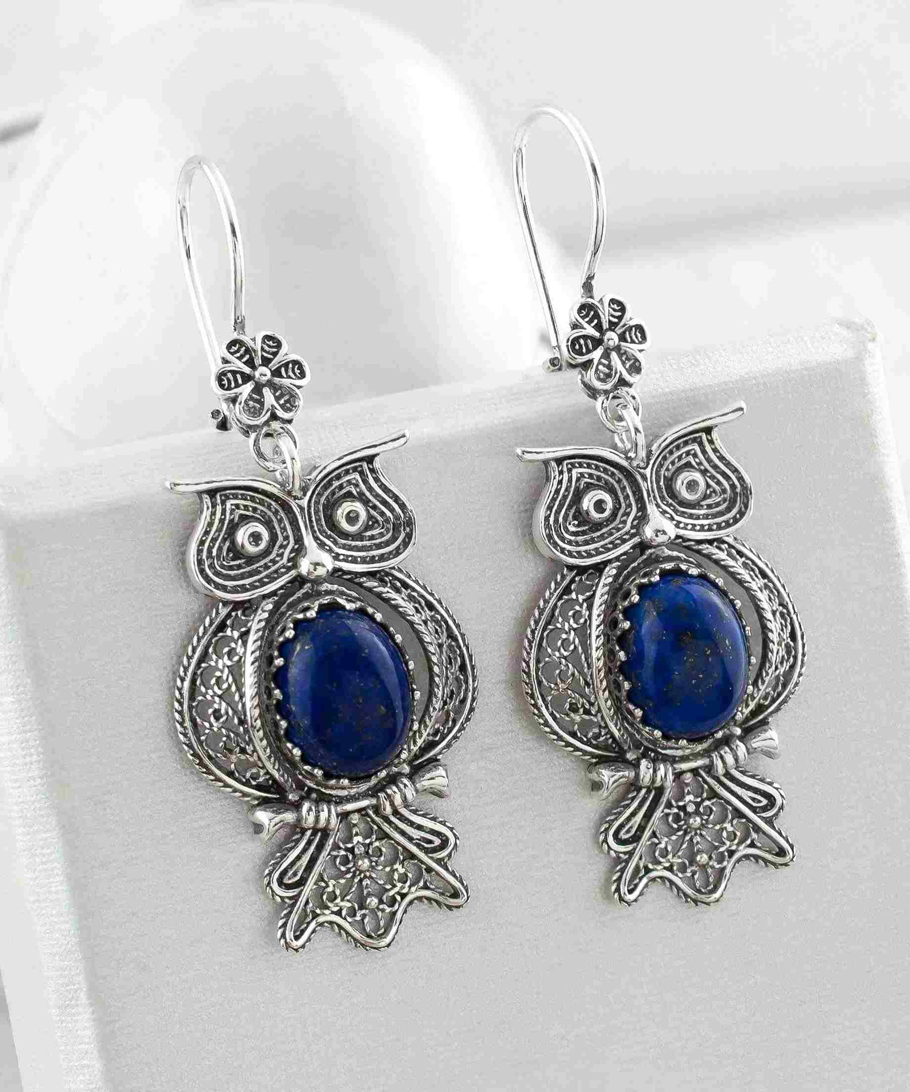 Elegant silver dangle earrings featuring owl design and Lapis Lazuli gemstone, showcasing intricate filigree craftsmanship.