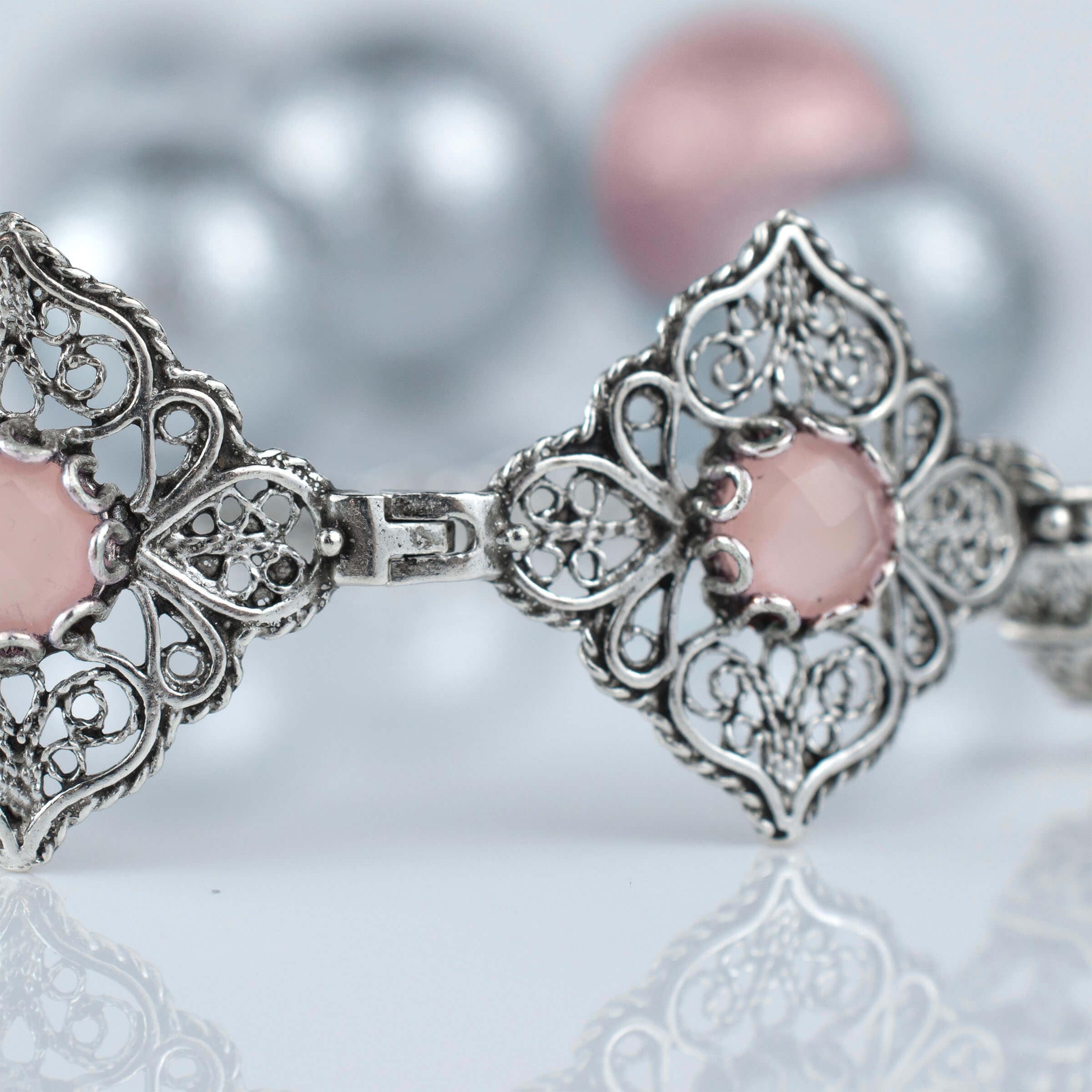 Elegant adjustable silver link bracelet featuring pink chalcedony gemstone in filigree art design.