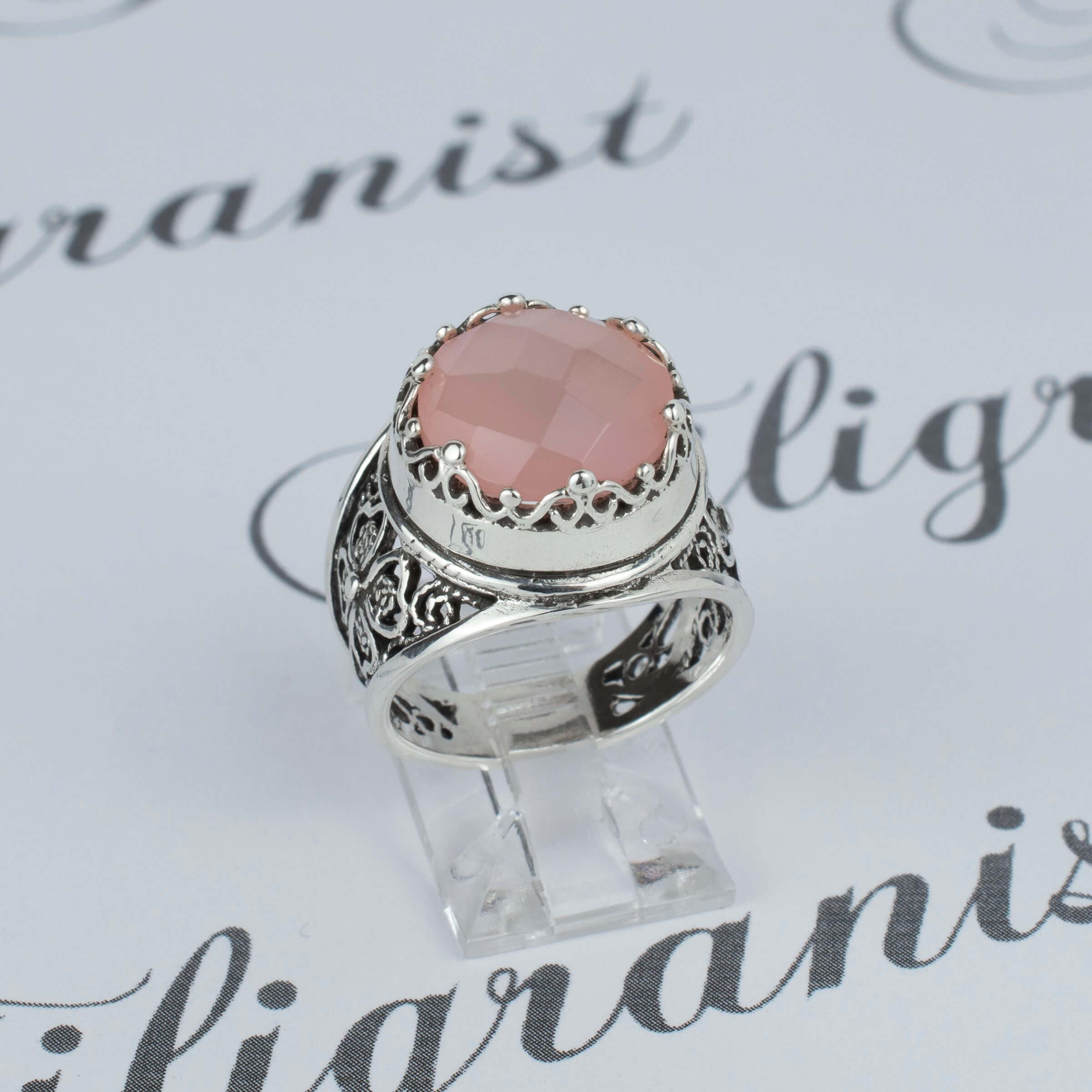 Sterling silver filigree art ring featuring a pink chalcedony gemstone, elegantly designed with intricate patterns.