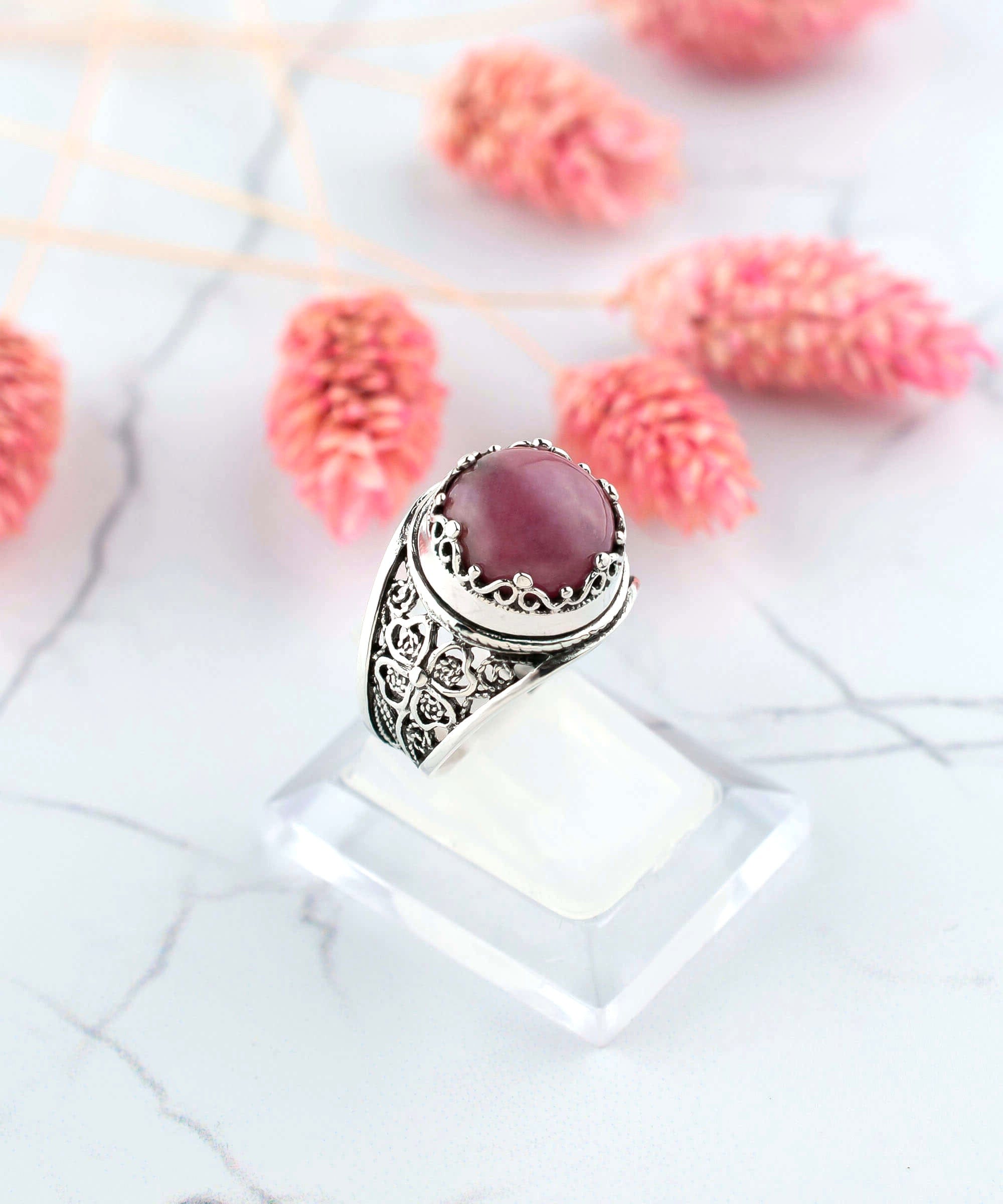 A stunning sterling silver filigree ring featuring a round cut rhodonite gemstone, elegantly designed for women.