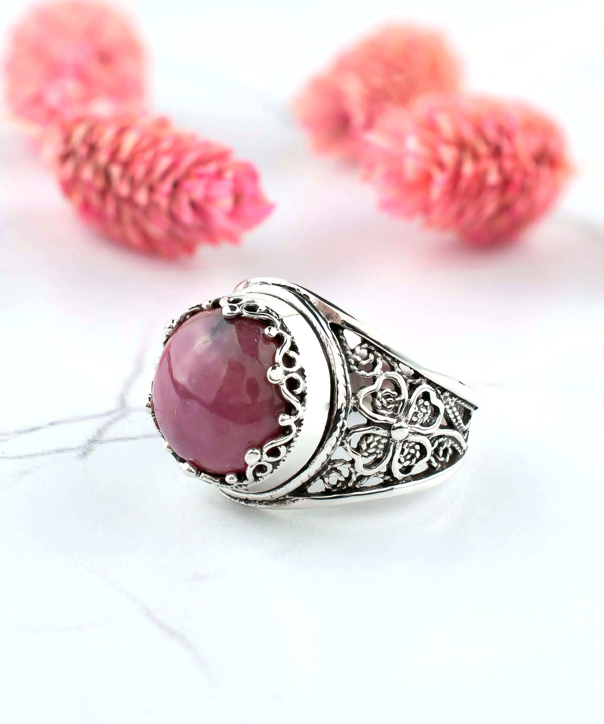 A stunning sterling silver filigree ring featuring a round cut rhodonite gemstone, elegantly designed for women.