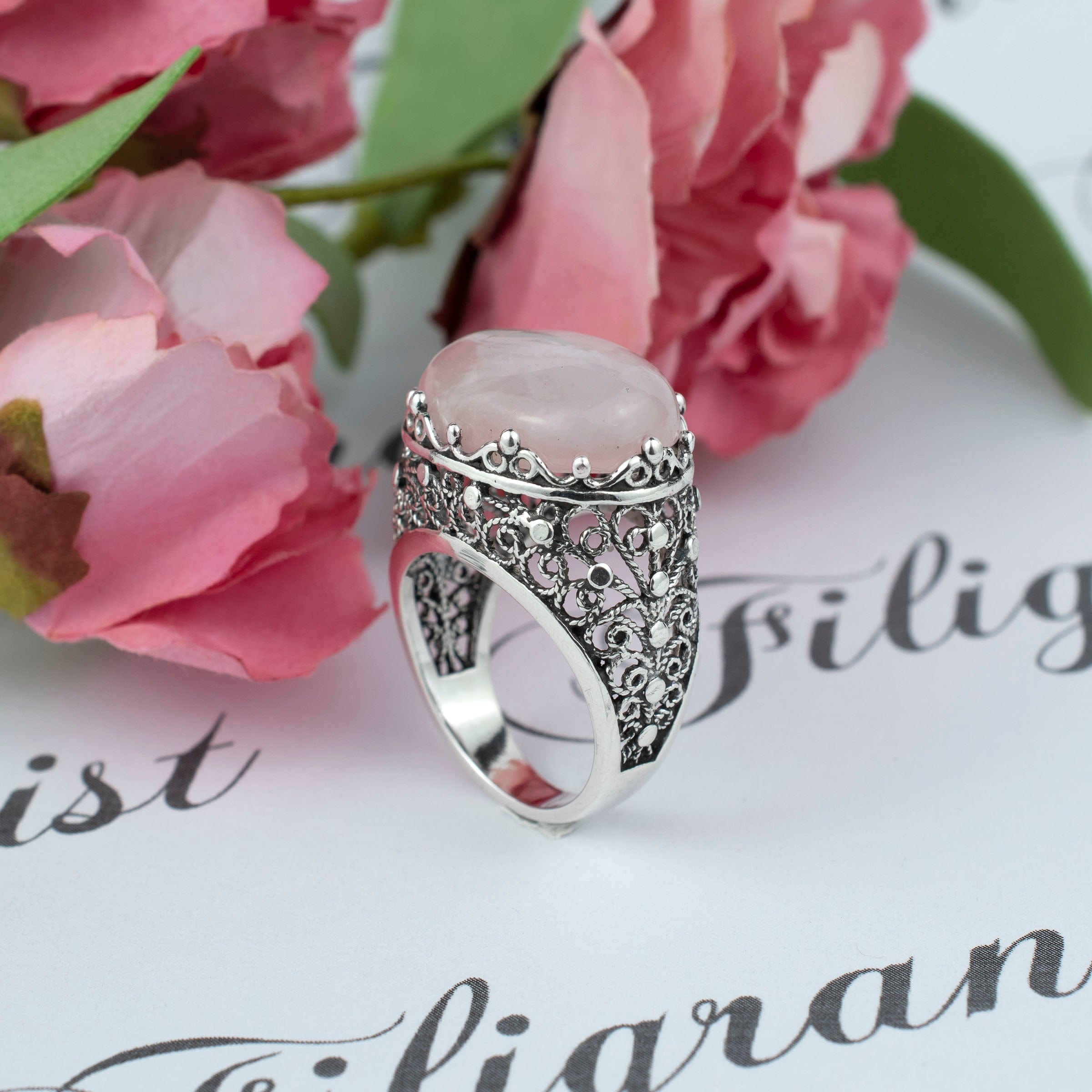 A beautifully crafted silver dome statement ring featuring a pink rose quartz gemstone set in intricate filigree art design.